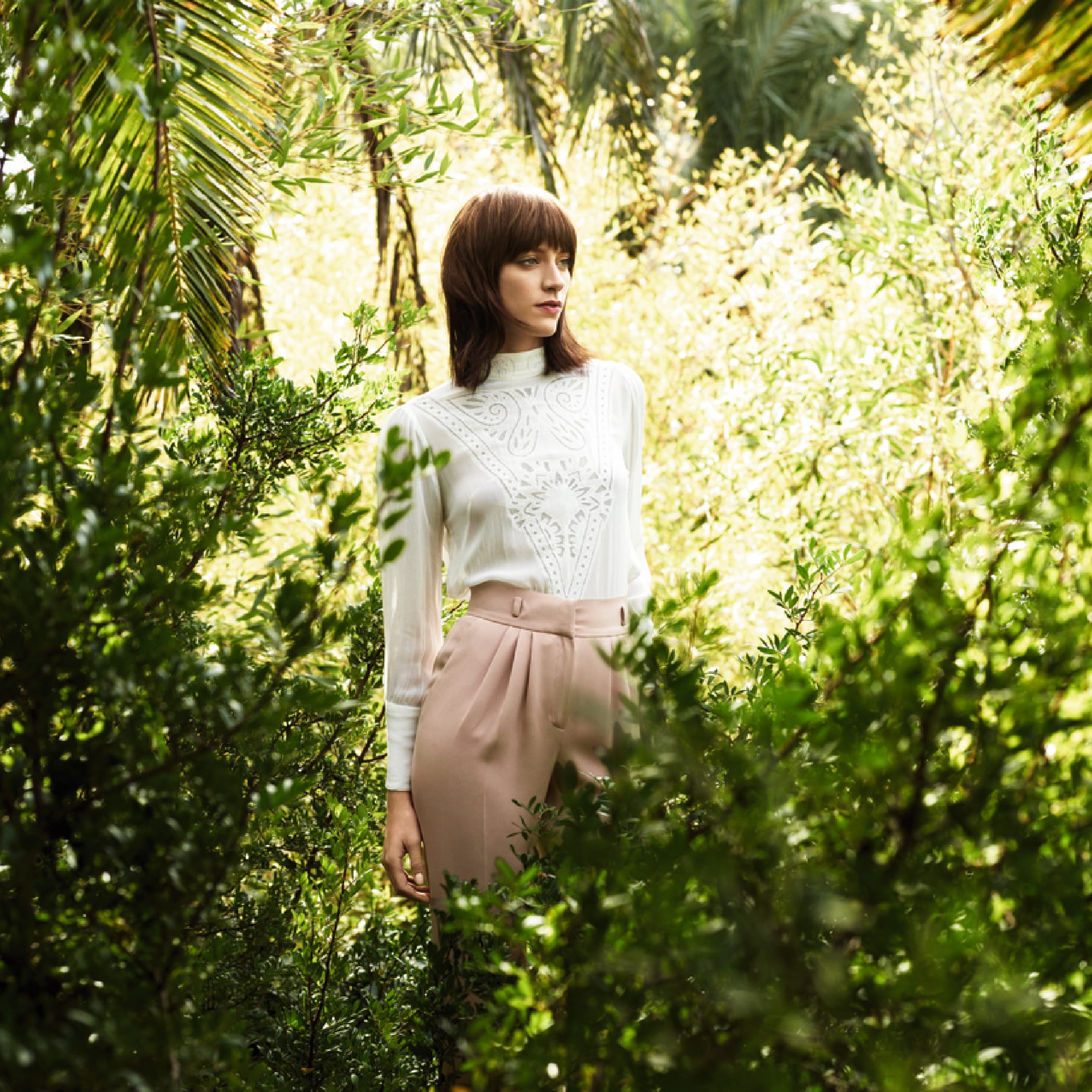 hochzwei_diel_teaser_01.jpg Model mit mittellangen brauen Haaren steht inmitten von Pflanzen