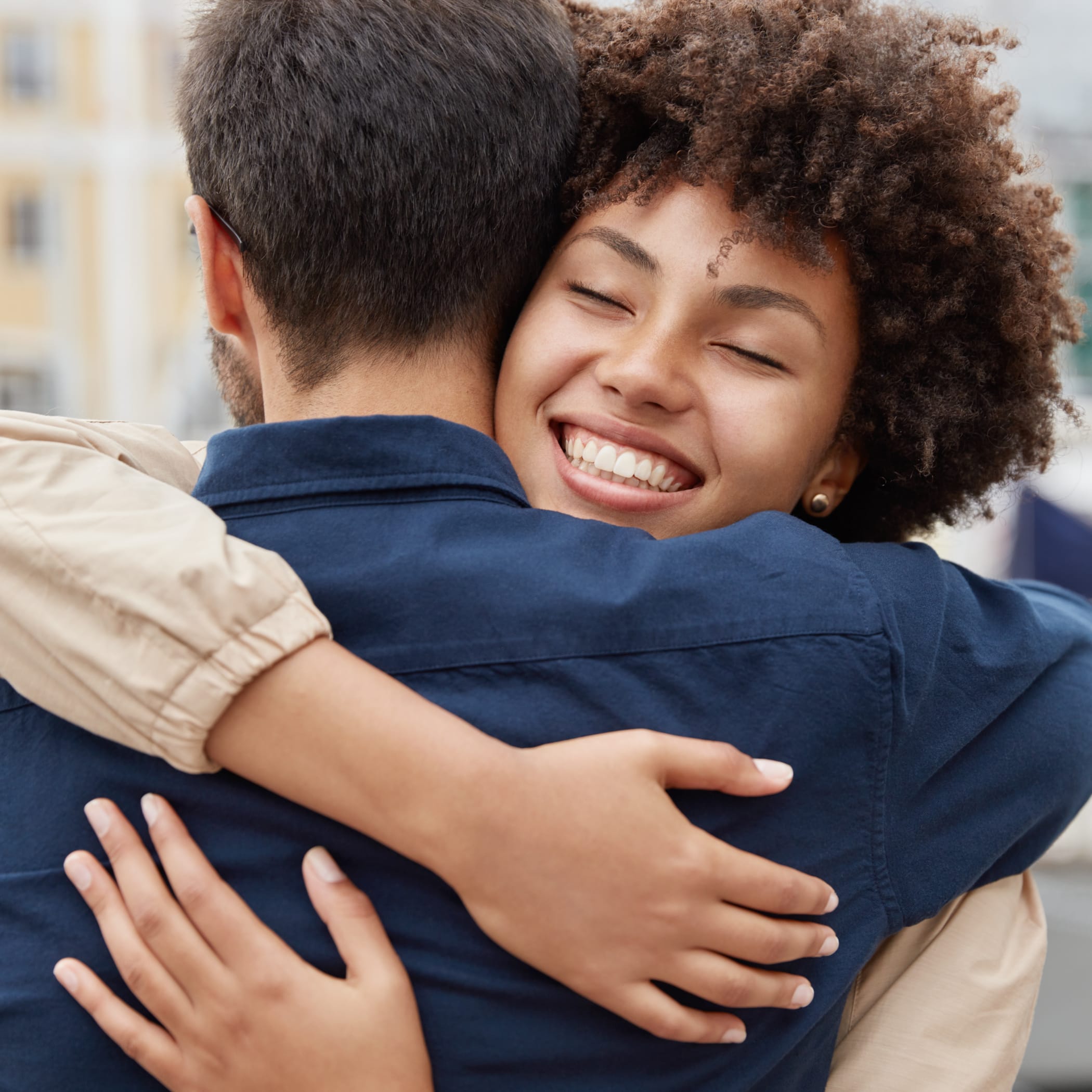 Lächelnde Frau umarmt innig einen Mann