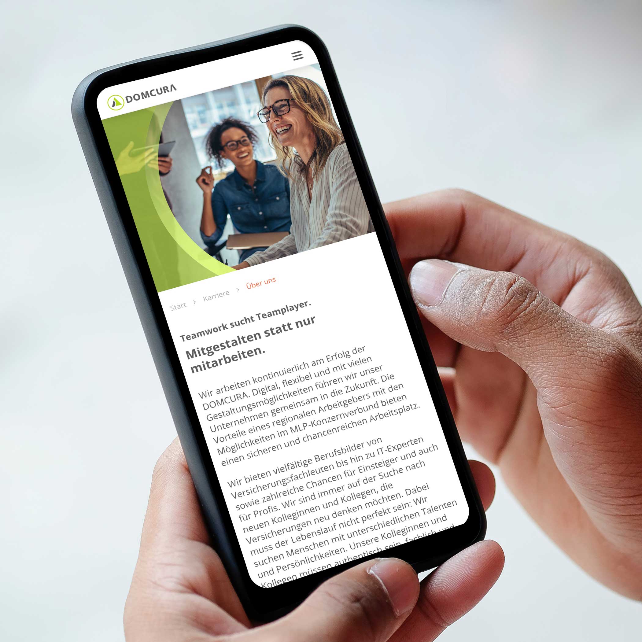 hochzwei_domcura_teaser_06.jpg In den Händen gehaltenes Smartphone, das die Website von Domcura zeigt