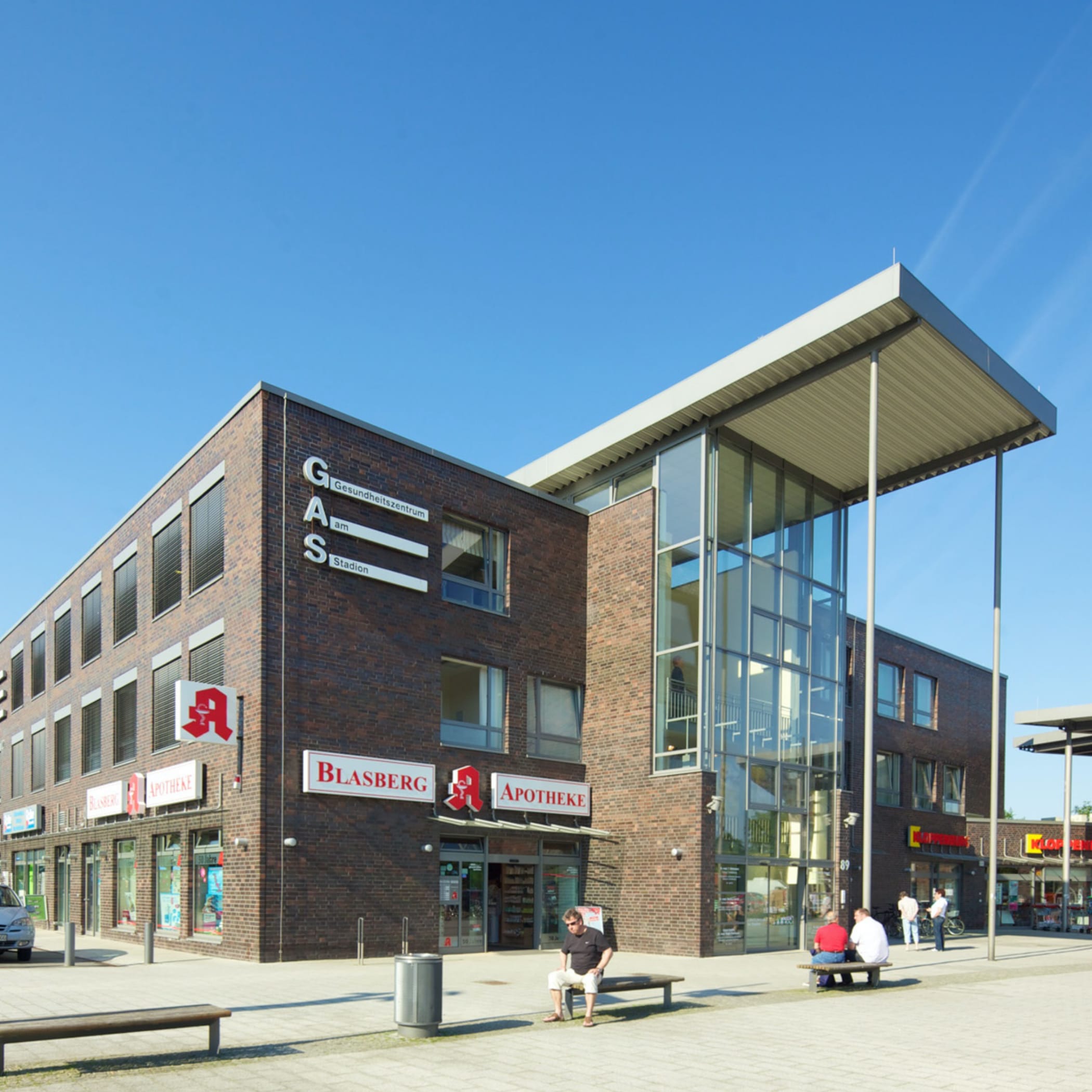 hochzwei_dran_teaser_01.jpg Dreistöckiges Flachdachgebäude mit hohem Glas-Eingangsvorbau