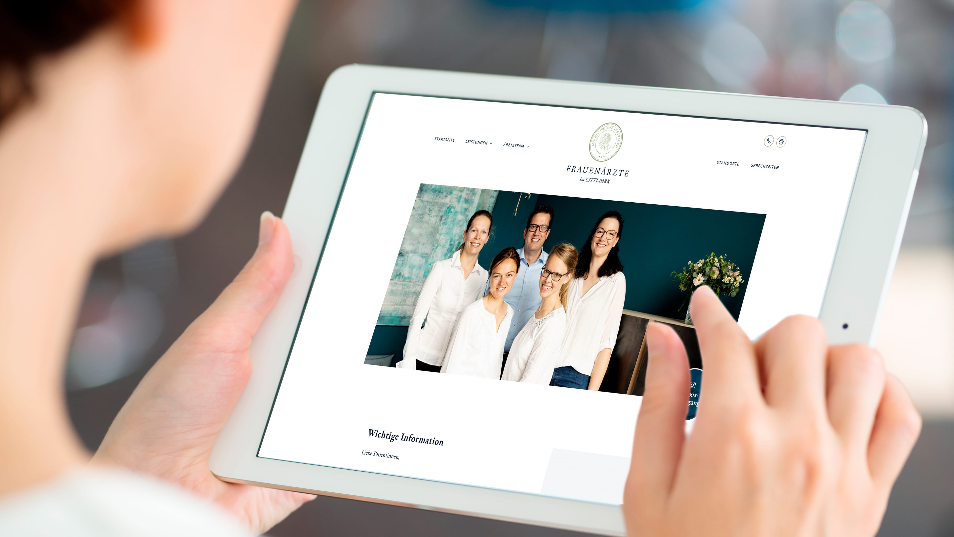 Person hält Tablet in den Händen, das die Website von Dr. Arne Raetz zeigt