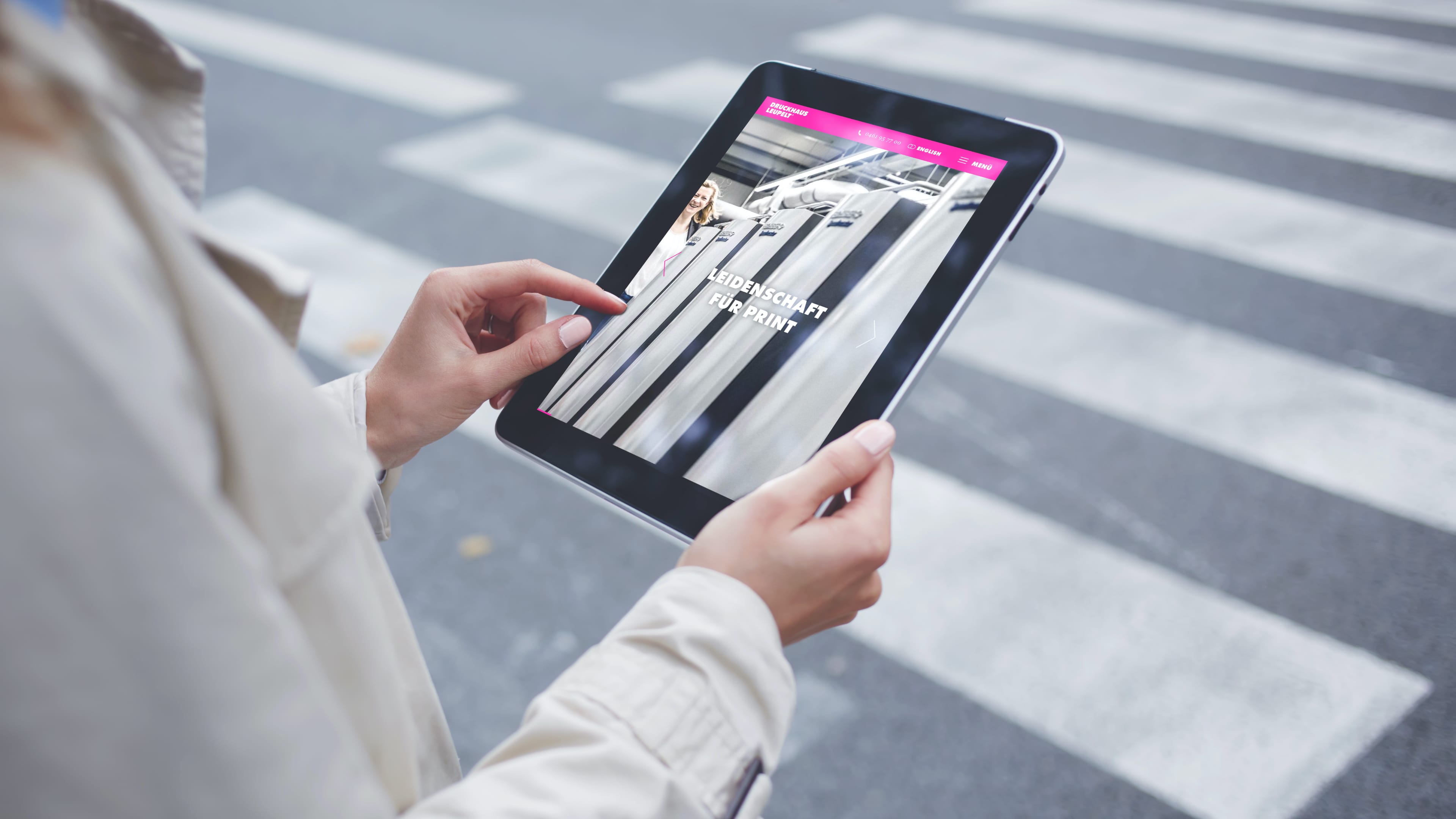 hochzwei_drle_slider_03.jpg In den Händen gehaltenes Tablet, das die Website vom Druckhaus Leupelt zeigt mit dem Text "Leidenschaft für Print"