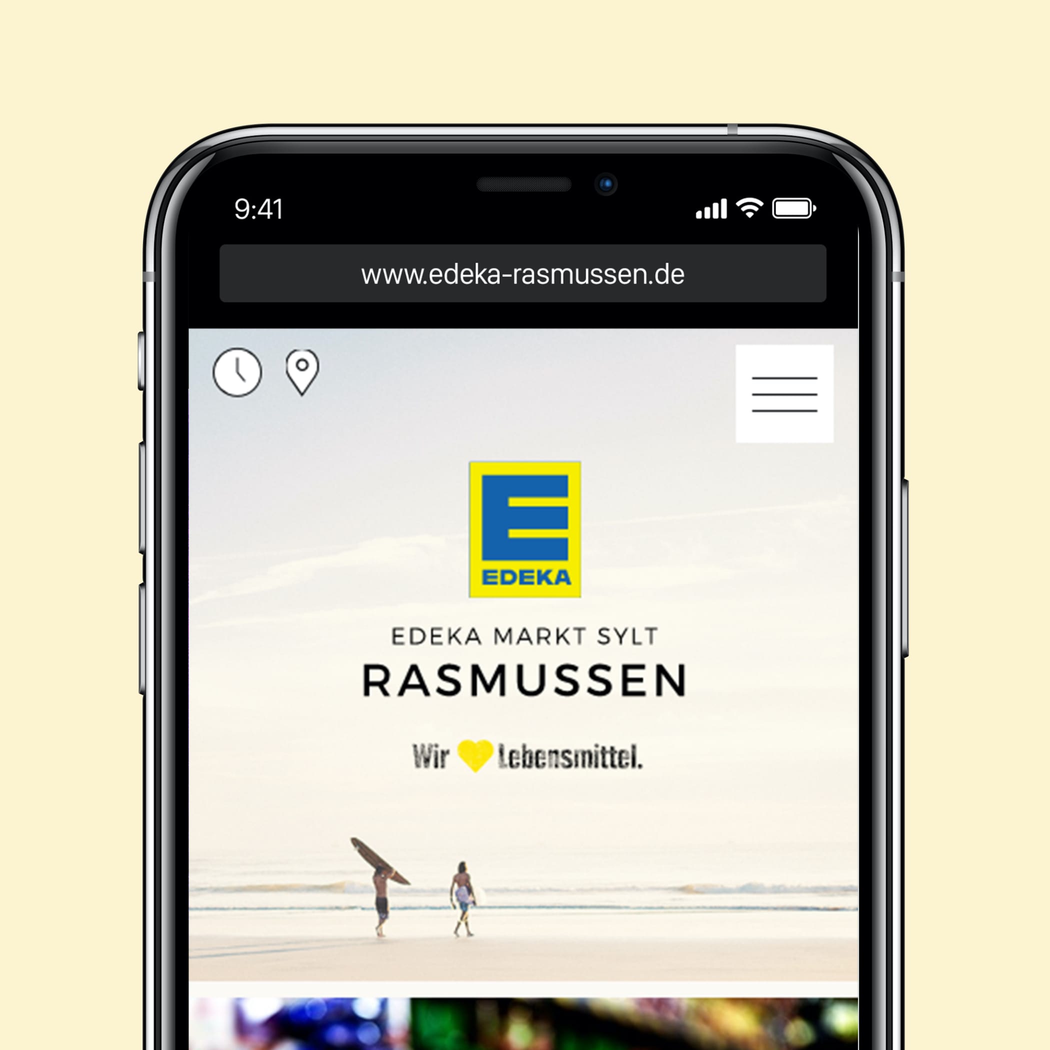 hochzwei_edra_teaser_02.jpg Smartphone zeigt Website edeka-rasmussen.de mit Foto vom Strand