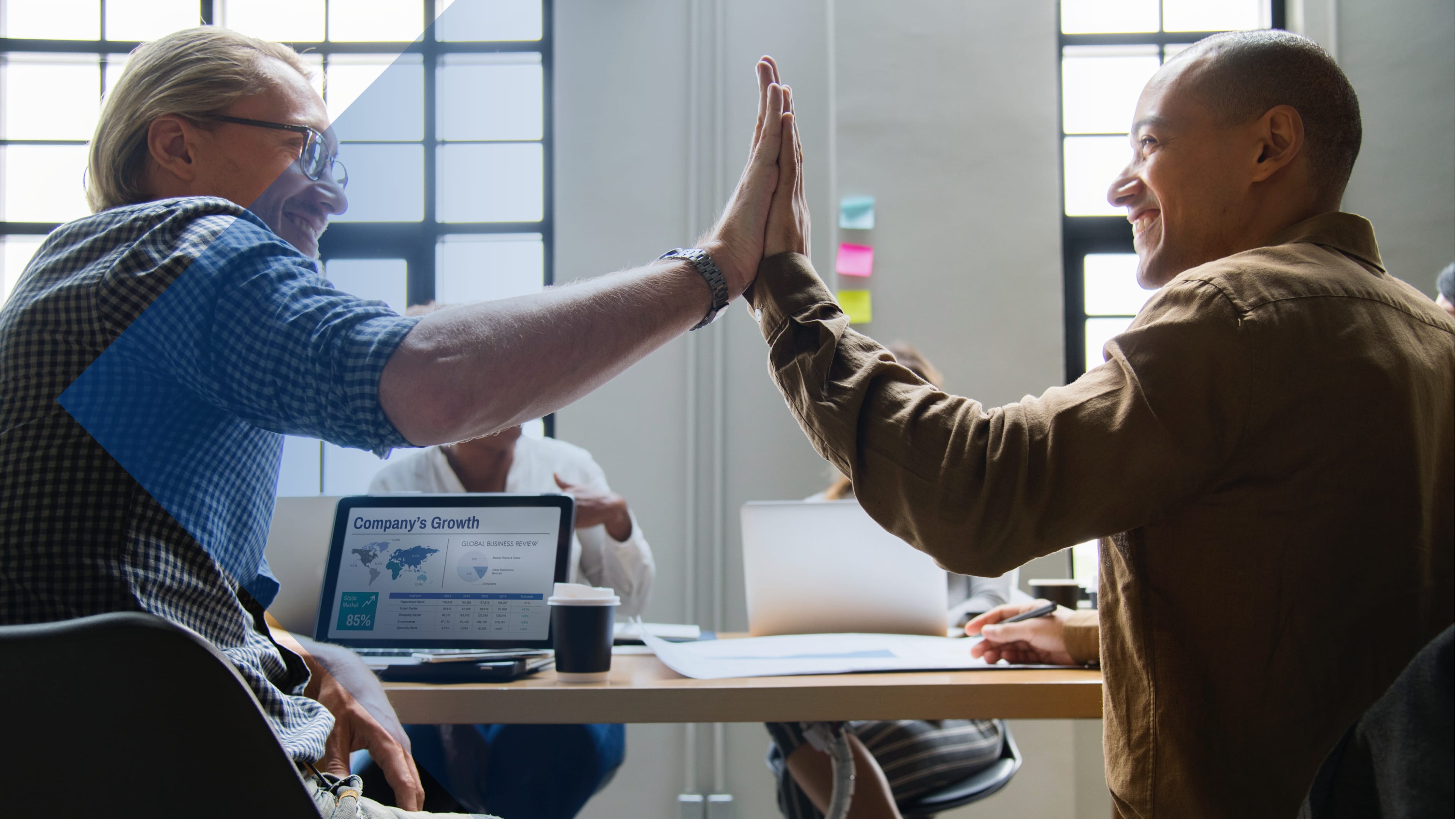 Zwei sitzende Kollegen im Besprechungsraum klatschen sich ab