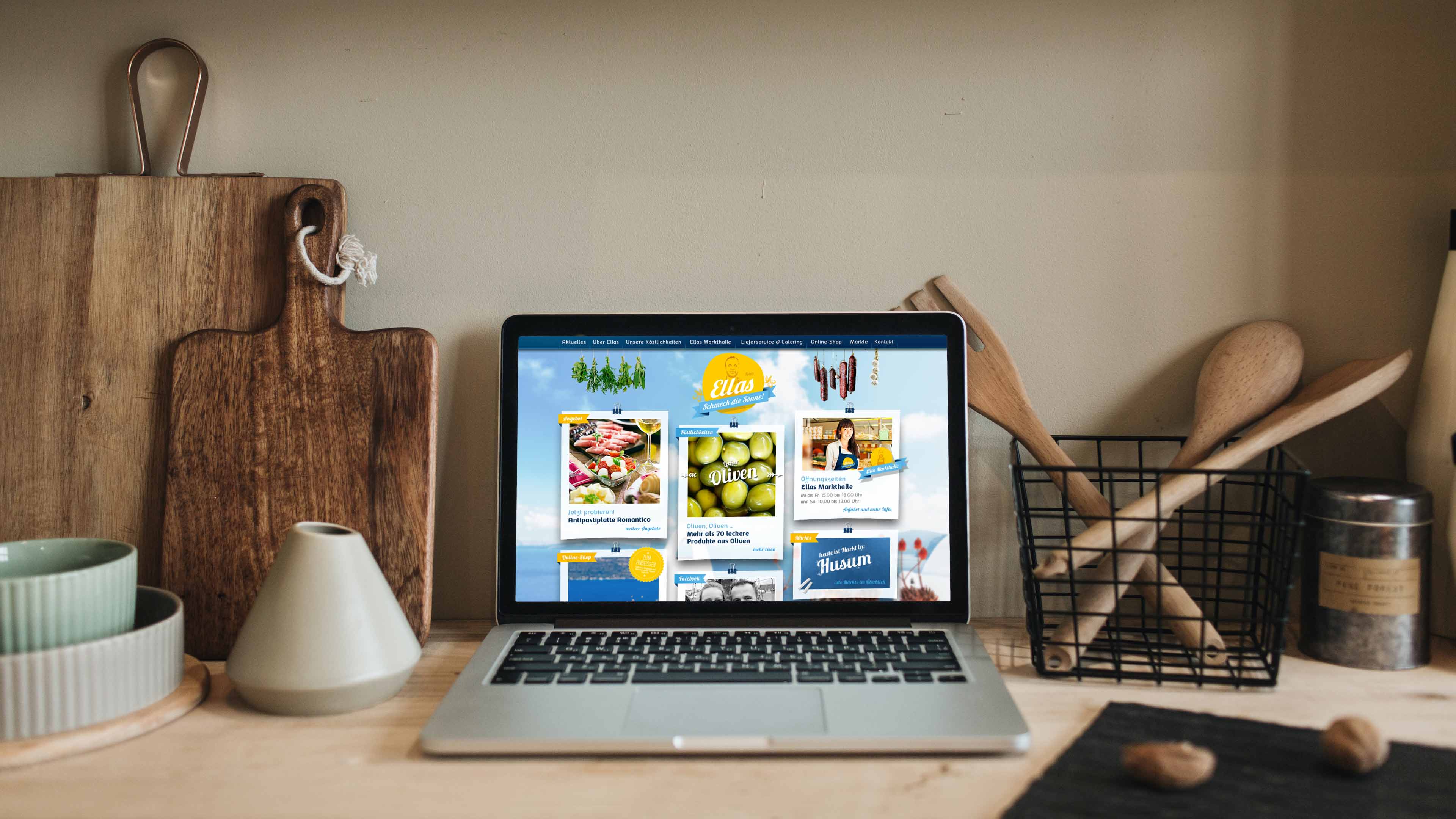 hochzwei_ella_slider_04.jpg Laptop in Küchenumgebung zeigt Websit von Ellas