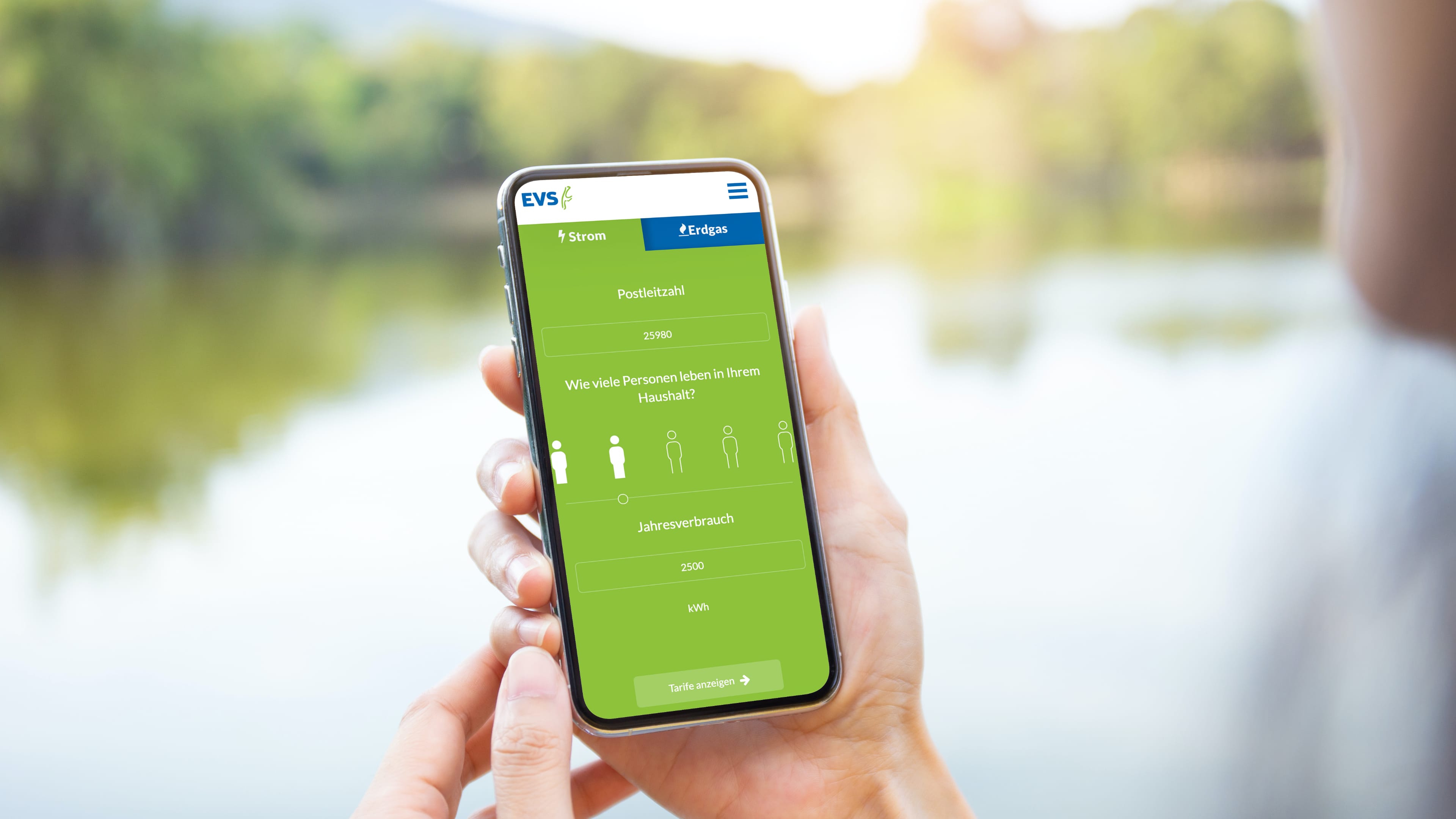 hochzwei_evs_slider_03.jpg Hand hält Smartphone, das grünen Stromrechner der Energieversorung Sylt zeigt