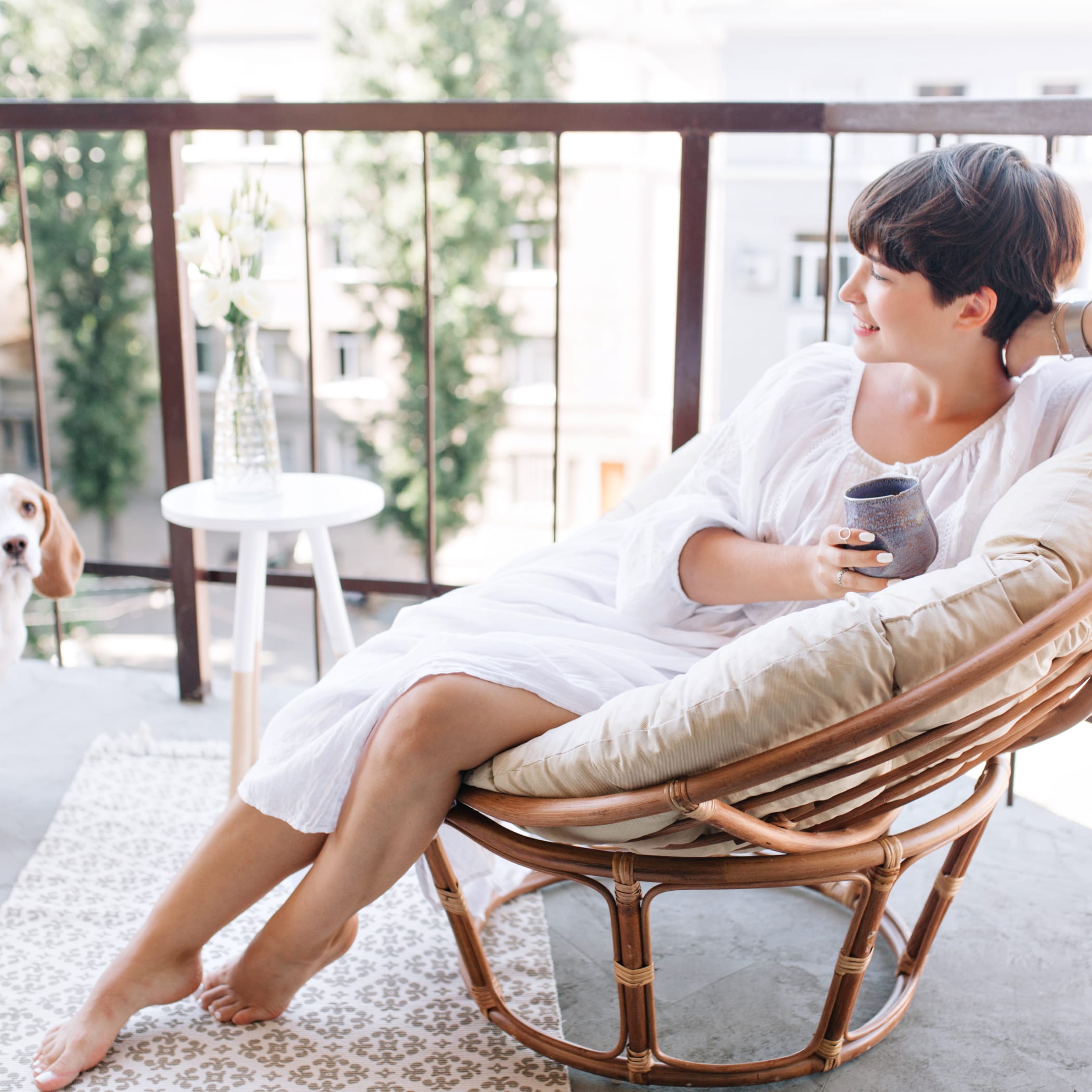 hochzwei_fab_teaser_03.jpg Entspannte Frau im Korbstuhl auf Balkon