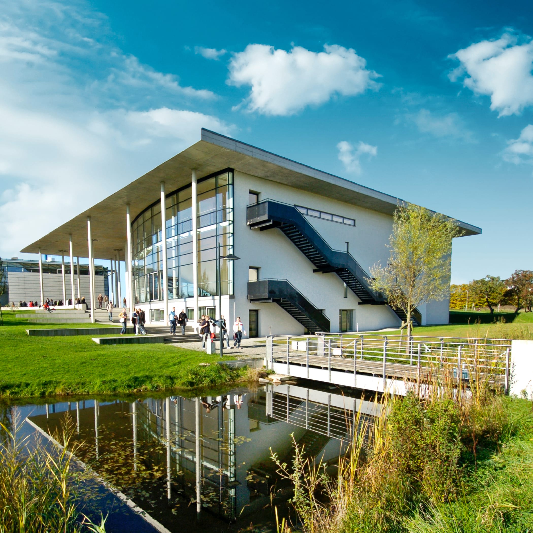 hochzwei_fhfl_teaser_05.jpg Hohes Uni-Gebäude mit Glasfront und Treppen