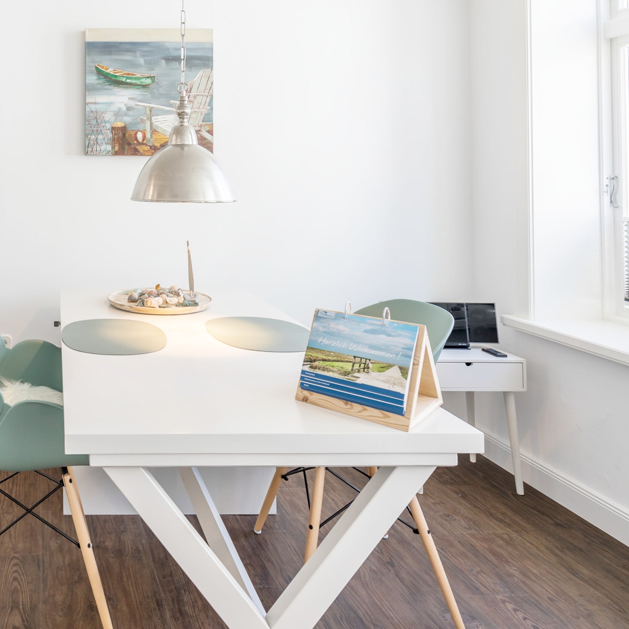 Willkommens-Aufsteller auf weißem Esstisch