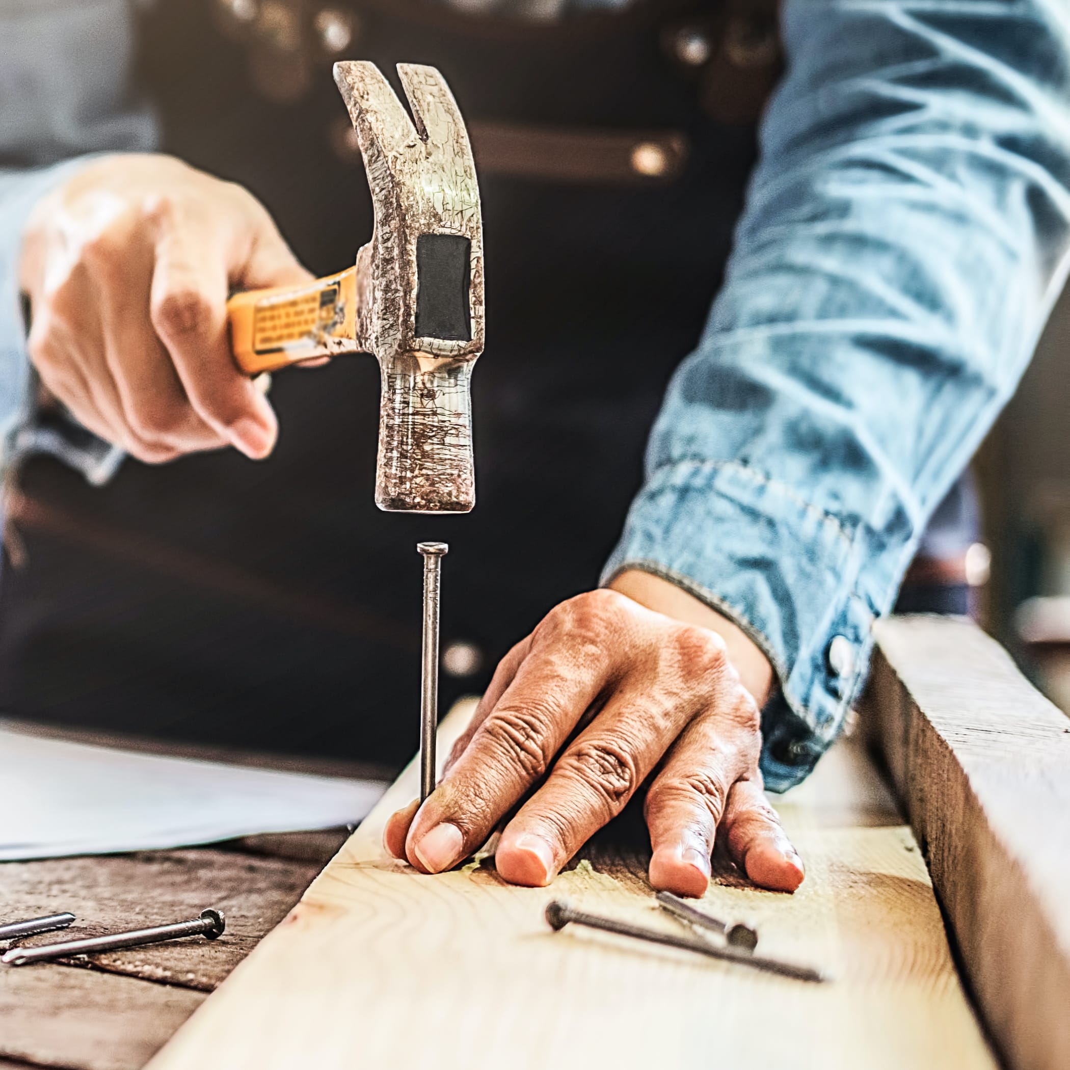 hochzwei_friedrichlange_teaser_03.jpg Ein Mann hämmert einen Nagel in ein Brett