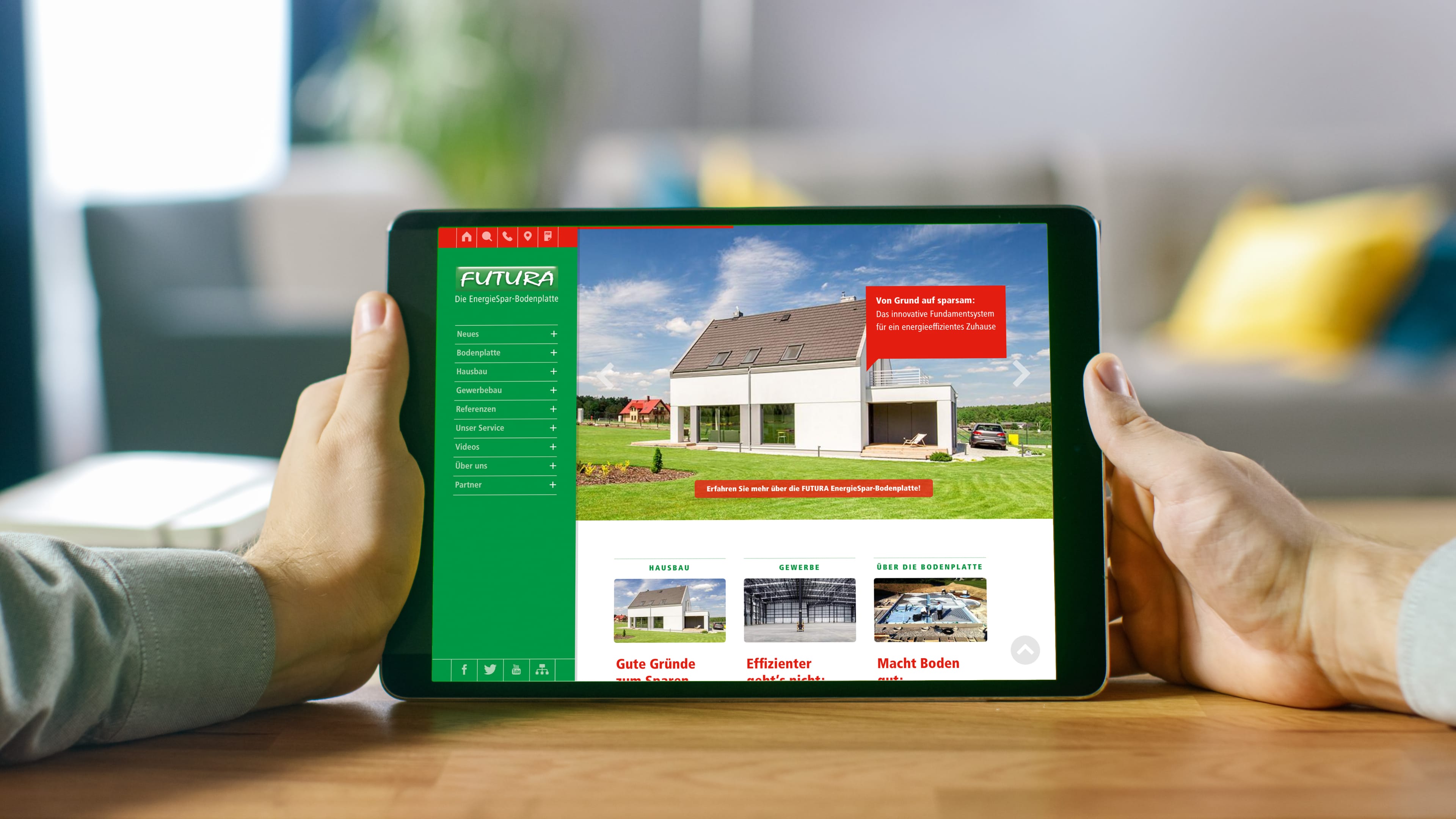 Ein Mann hält ein Ipad in der Hand mit der Futura Hoempage