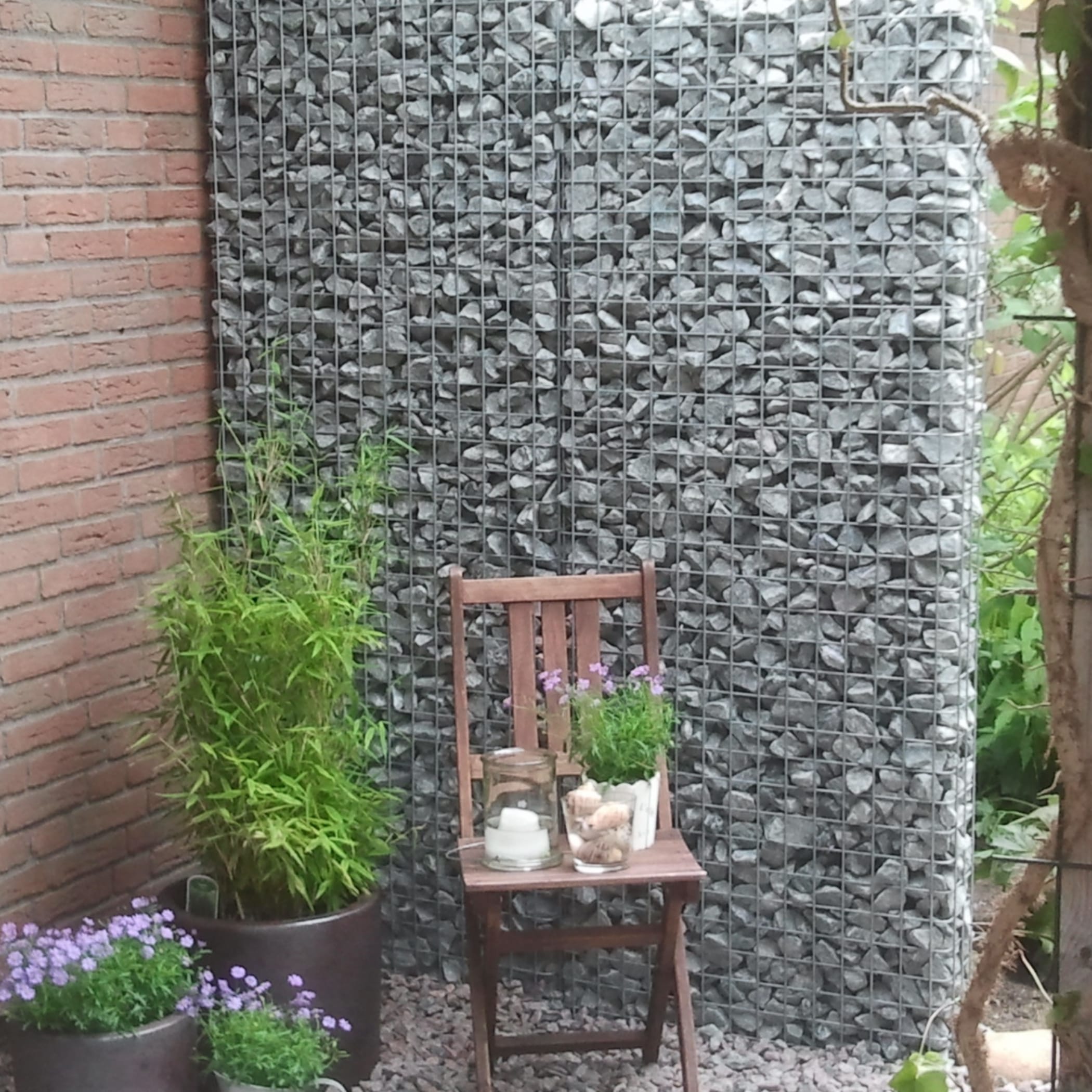 Ein Holzstuhl steht in der Ecke eines Gartens