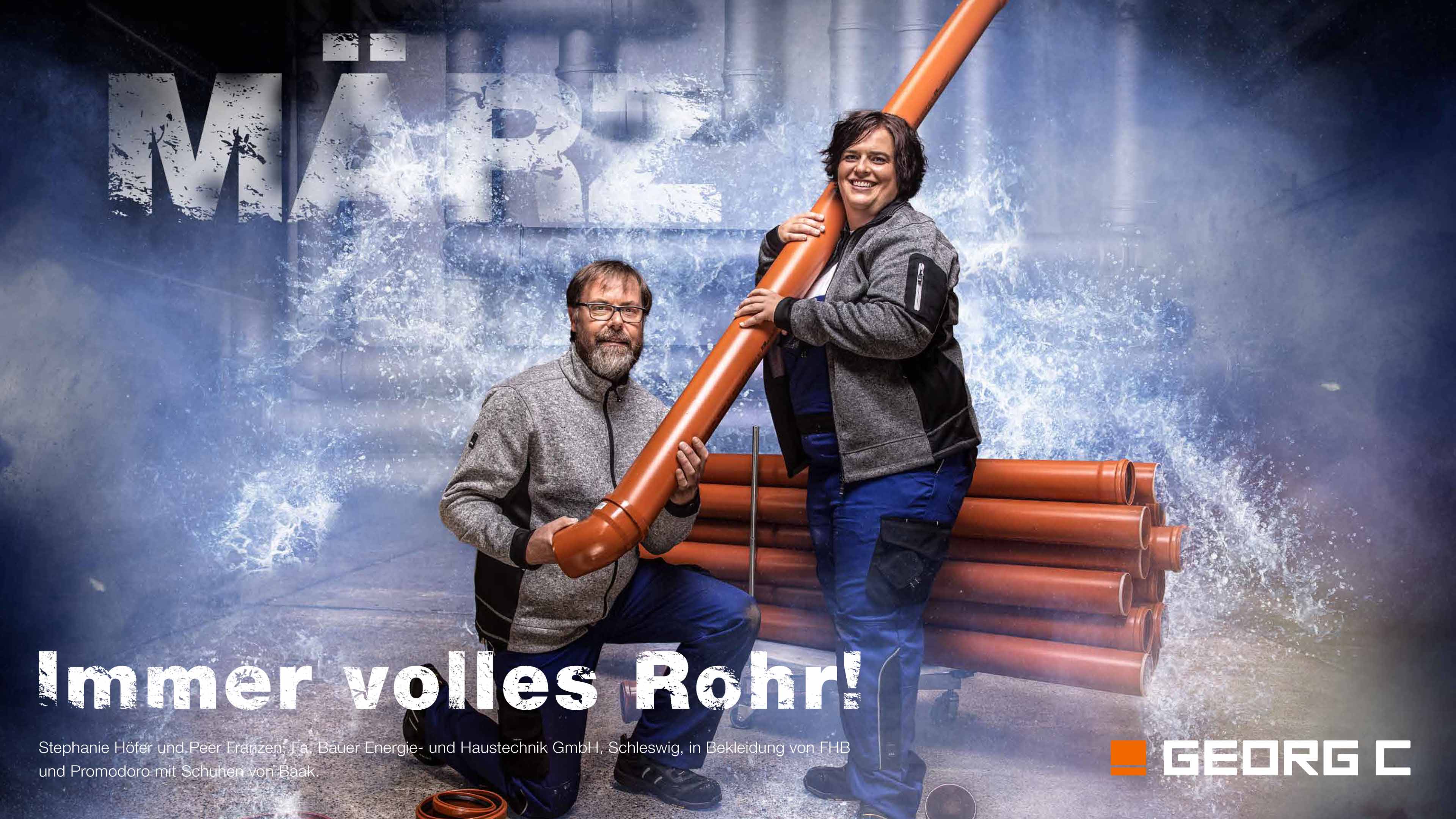 Zwei Georg C Mitarbeiter posieren mit einem Rohr vor der Kamera