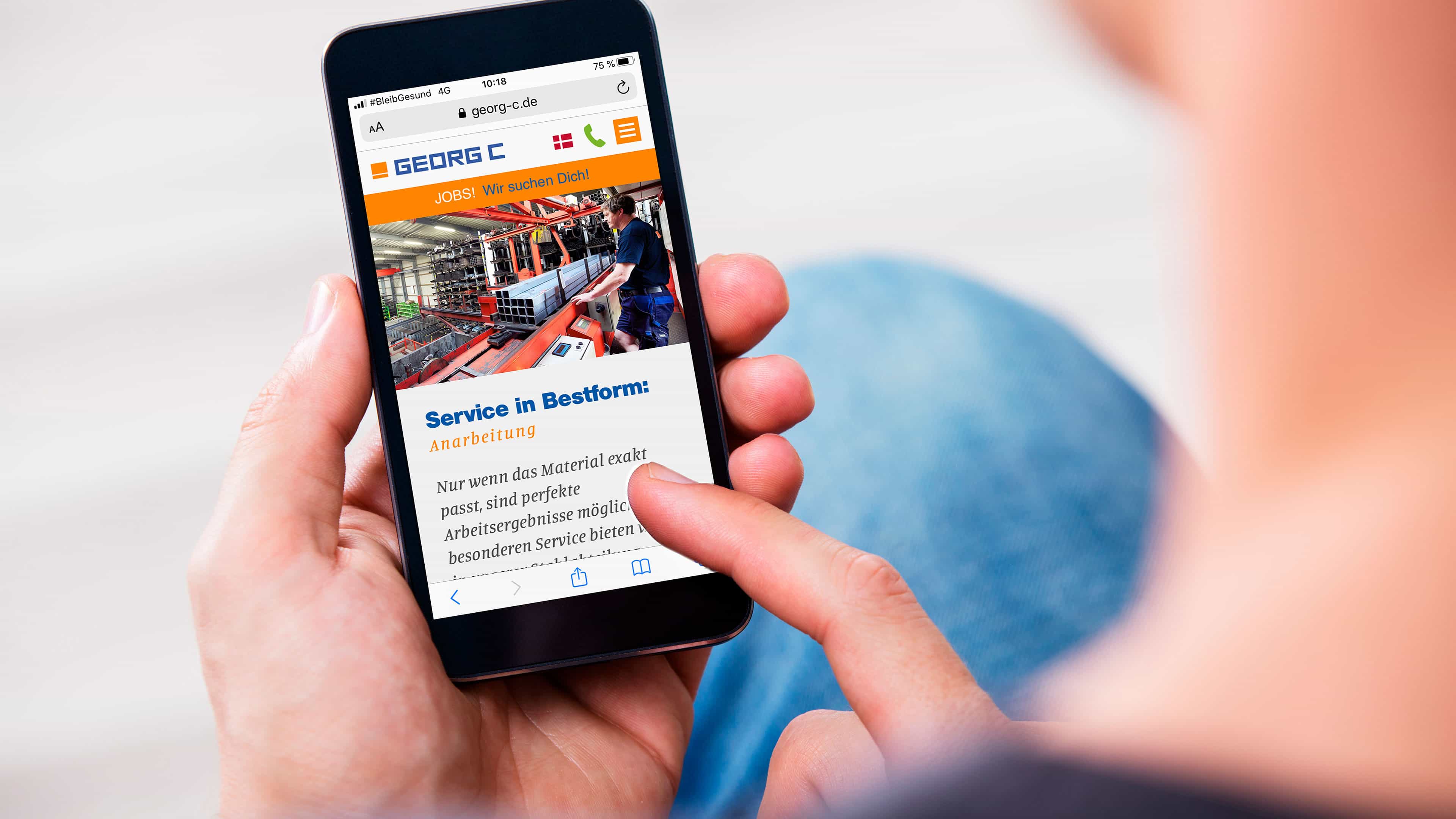 hochzwei_georgc_slider_03.jpg Eine person surft über ein Smartphone auf der Georg C Homepage