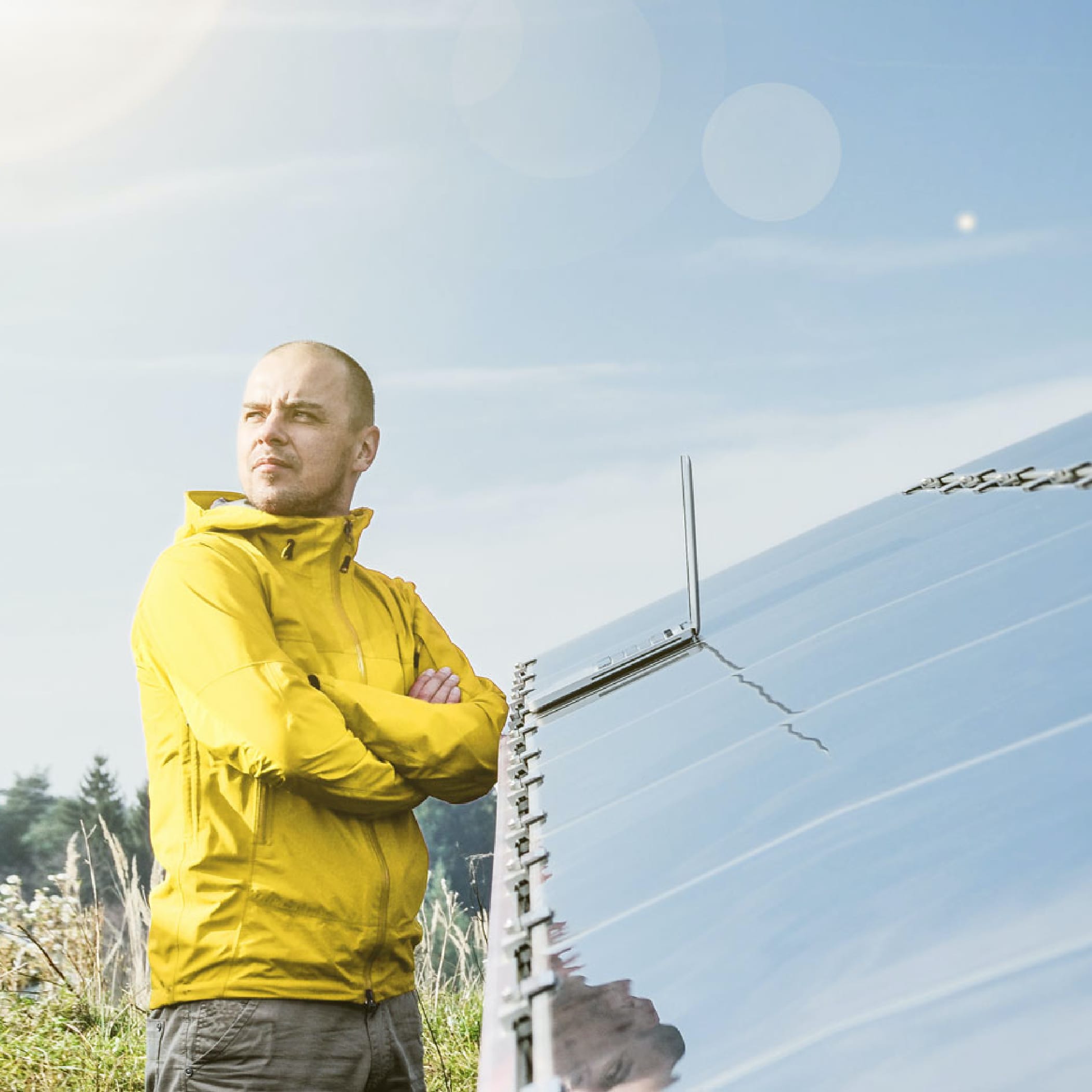 hochzwei_gp_james_teaser_09.jpg Ein Mann in gelber Jacke steht mit verschränkten Armen vor einer Solaranlage