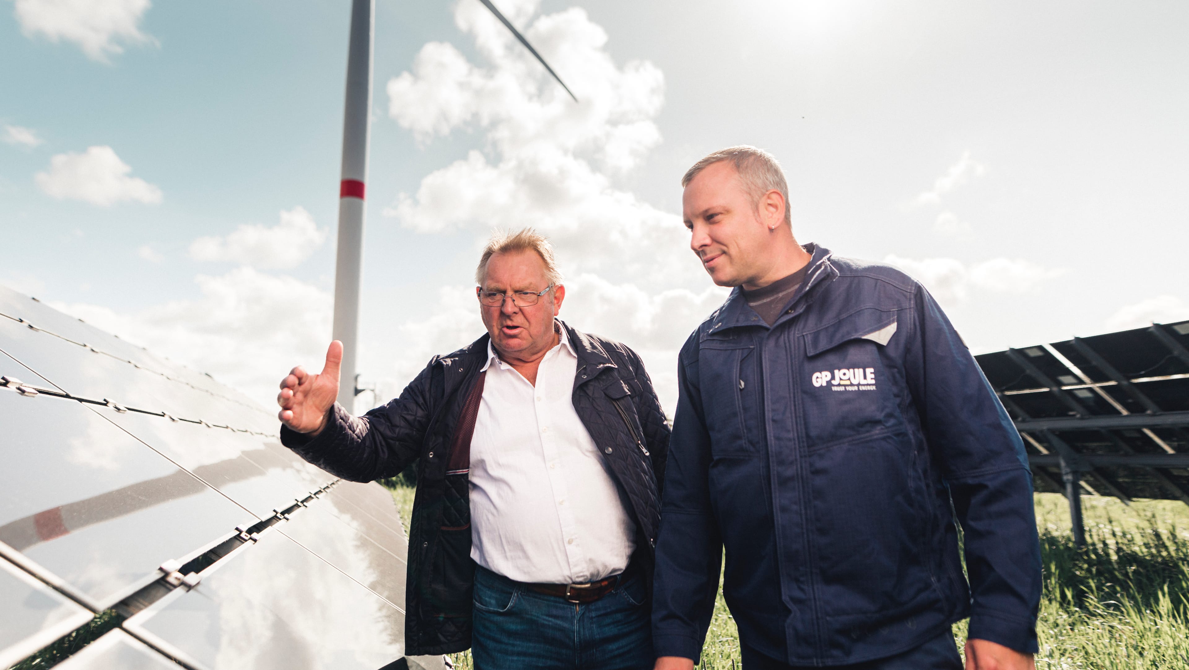 hochzwei_gp_slider_02.jpg Zwei Männer reden vor einer Solaranlage
