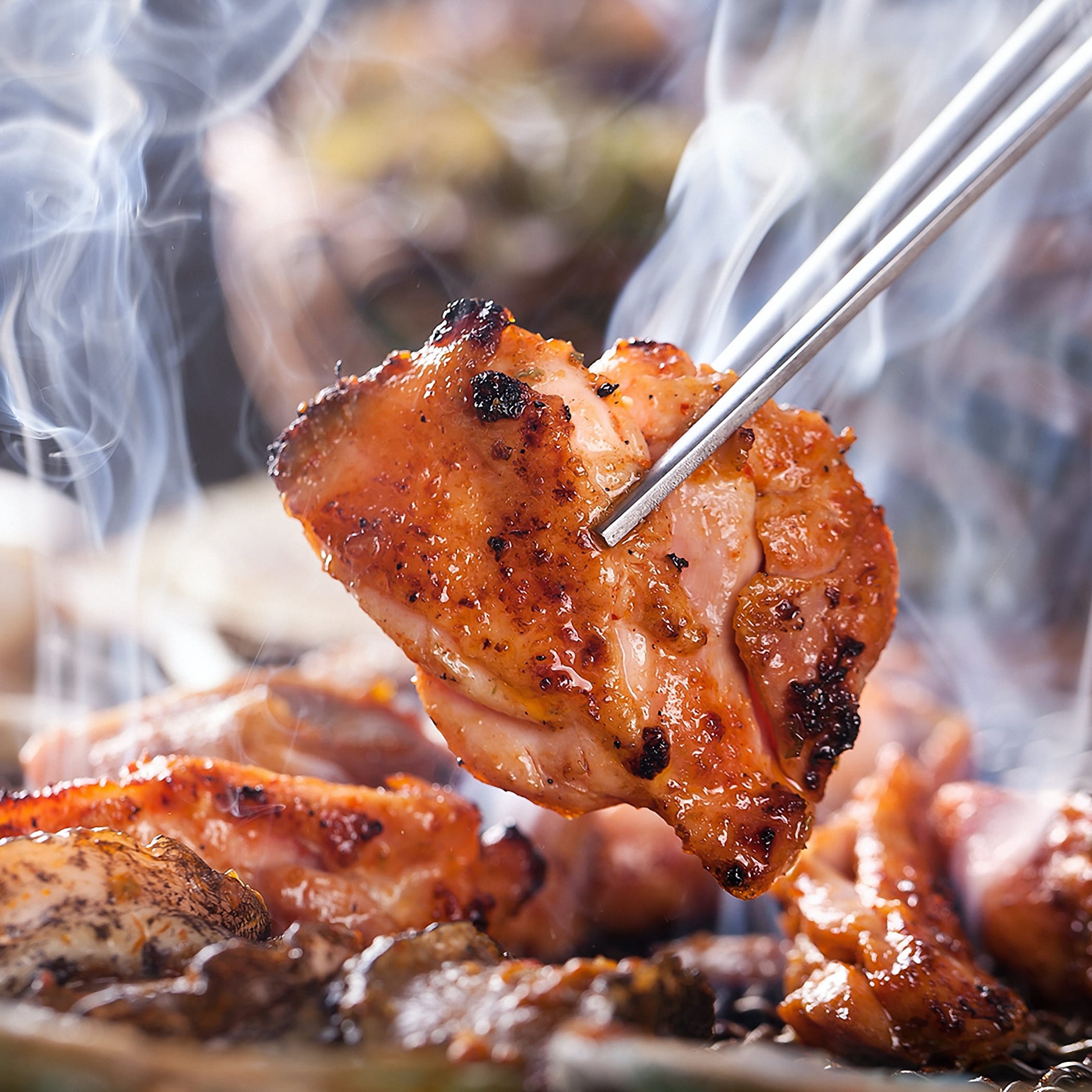 hochzwei_haba_teaser_02.jpg Eine Zange hält ein Stück BBQ