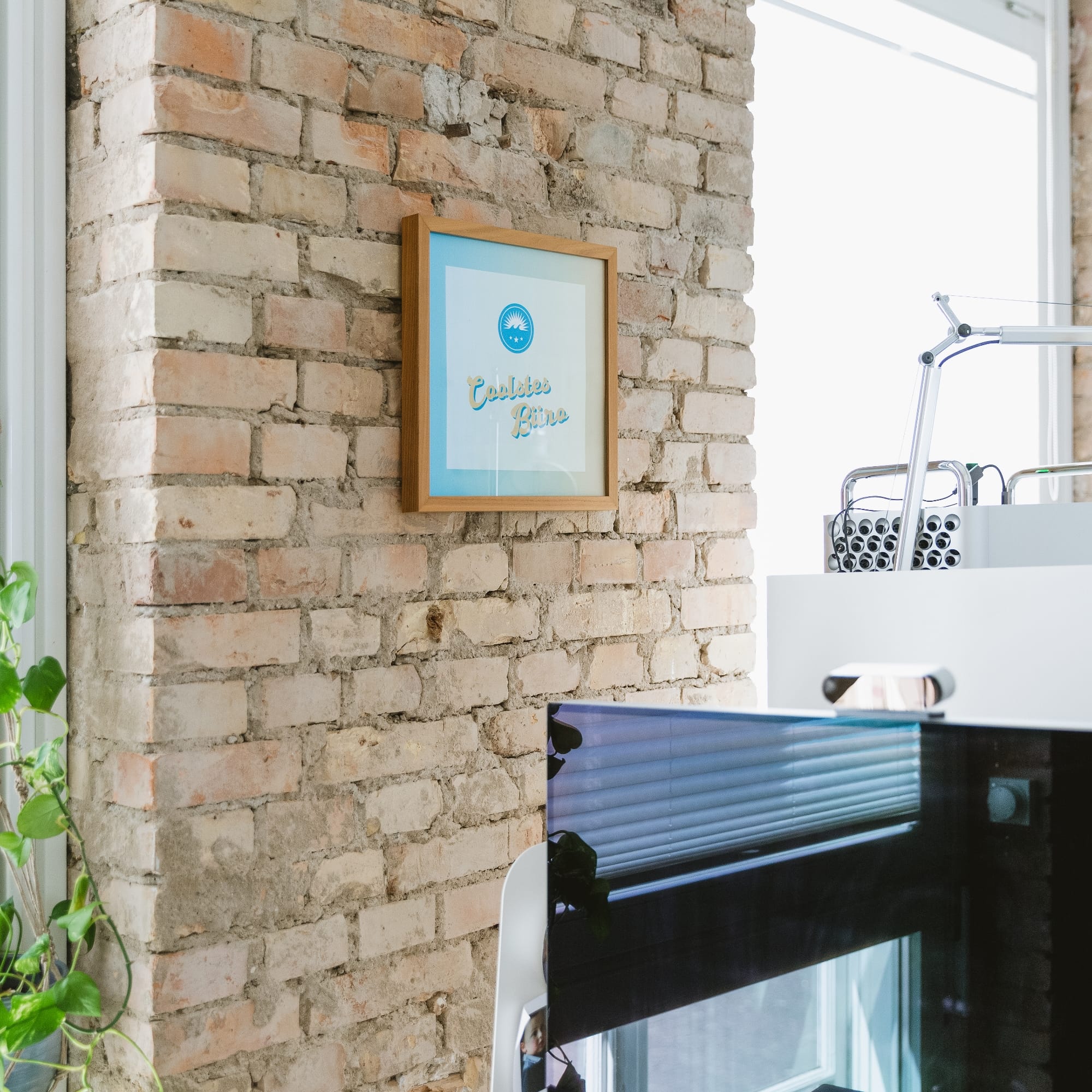 h2_wachstum_teaser_01.jpg Ein eingerahmtes Bild hängt an der Wand im Hochzwei Büro