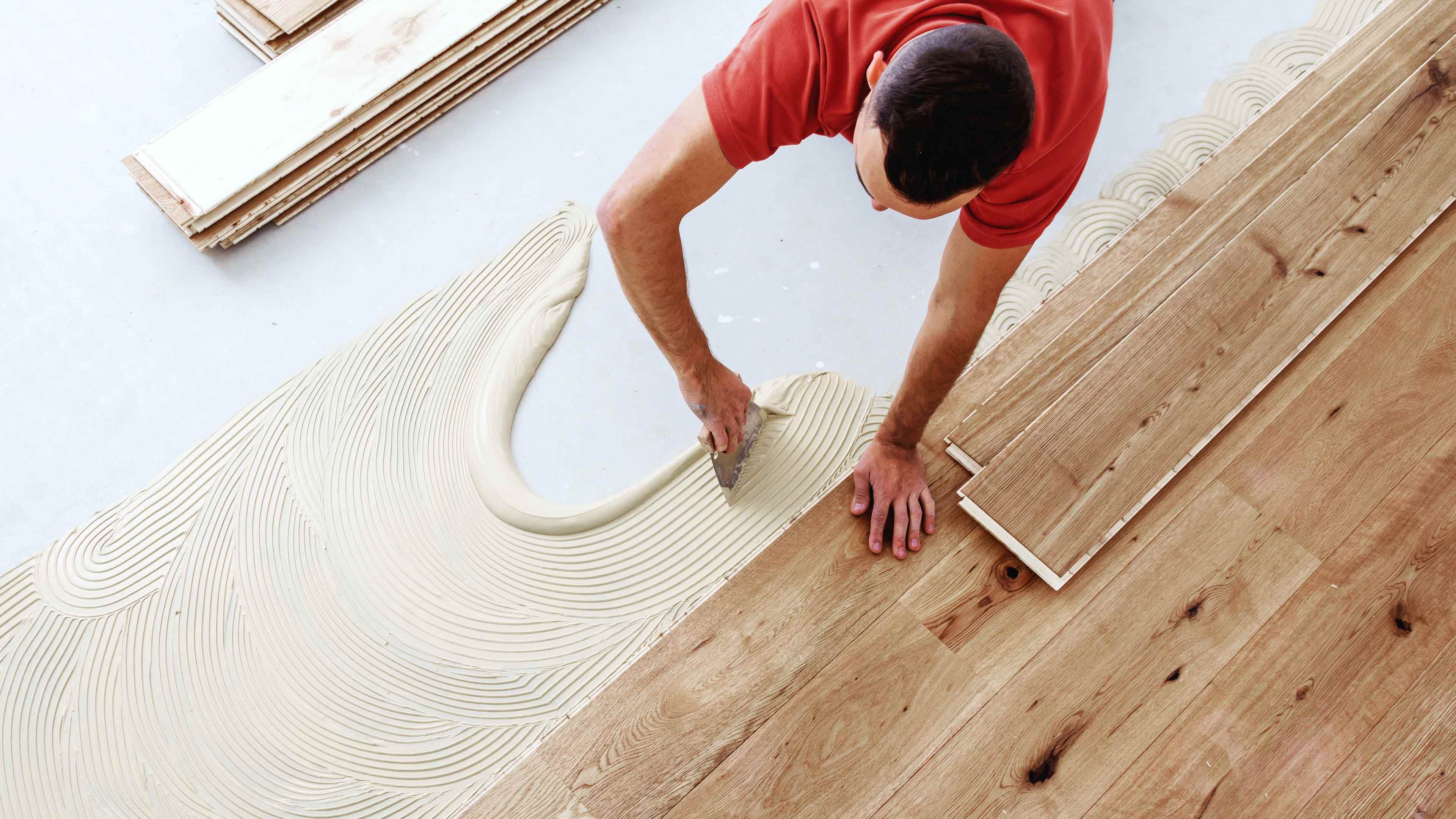 Ein Mann verlegt Parket auf dem Boden