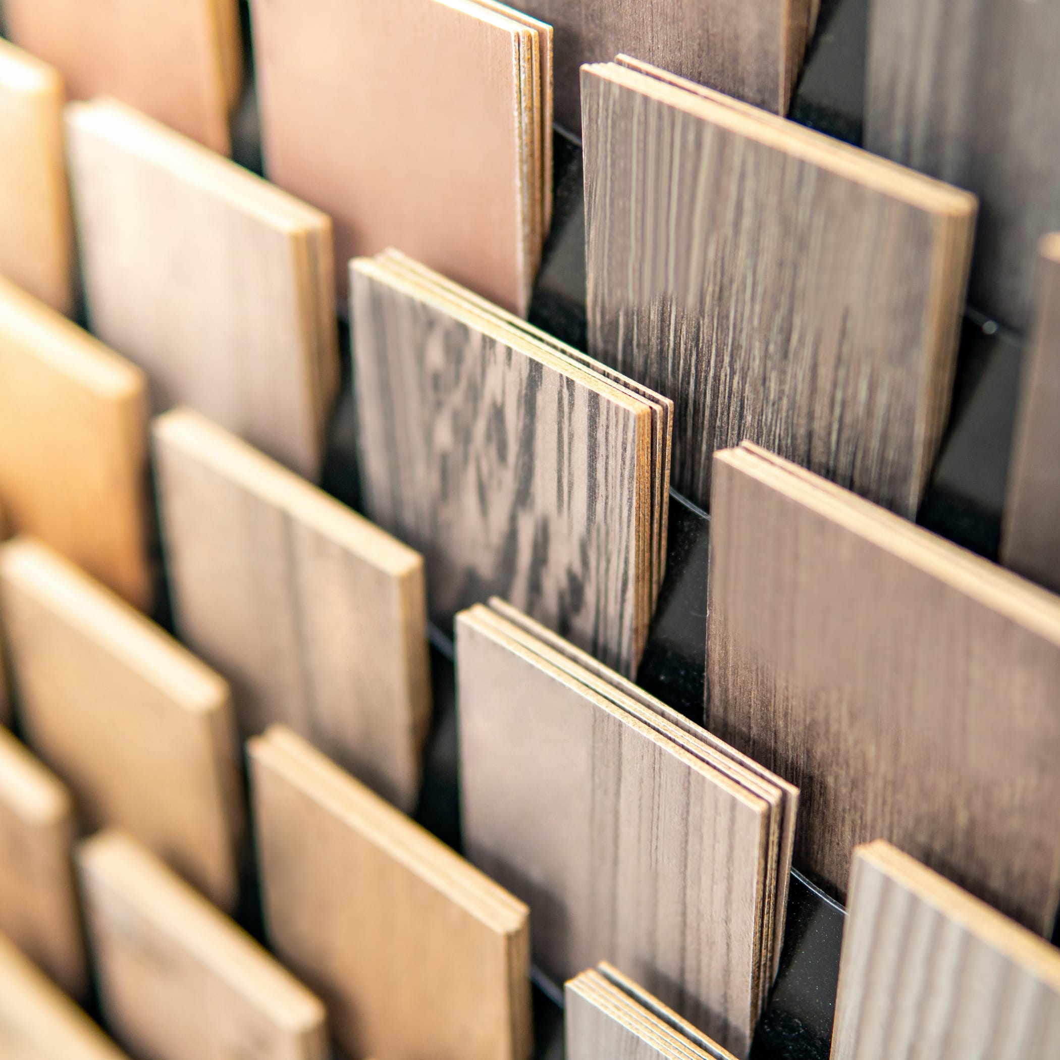 hochzwei_holz_teaser_01.jpg Verschiedene Holzfarben stehen in einem Regal
