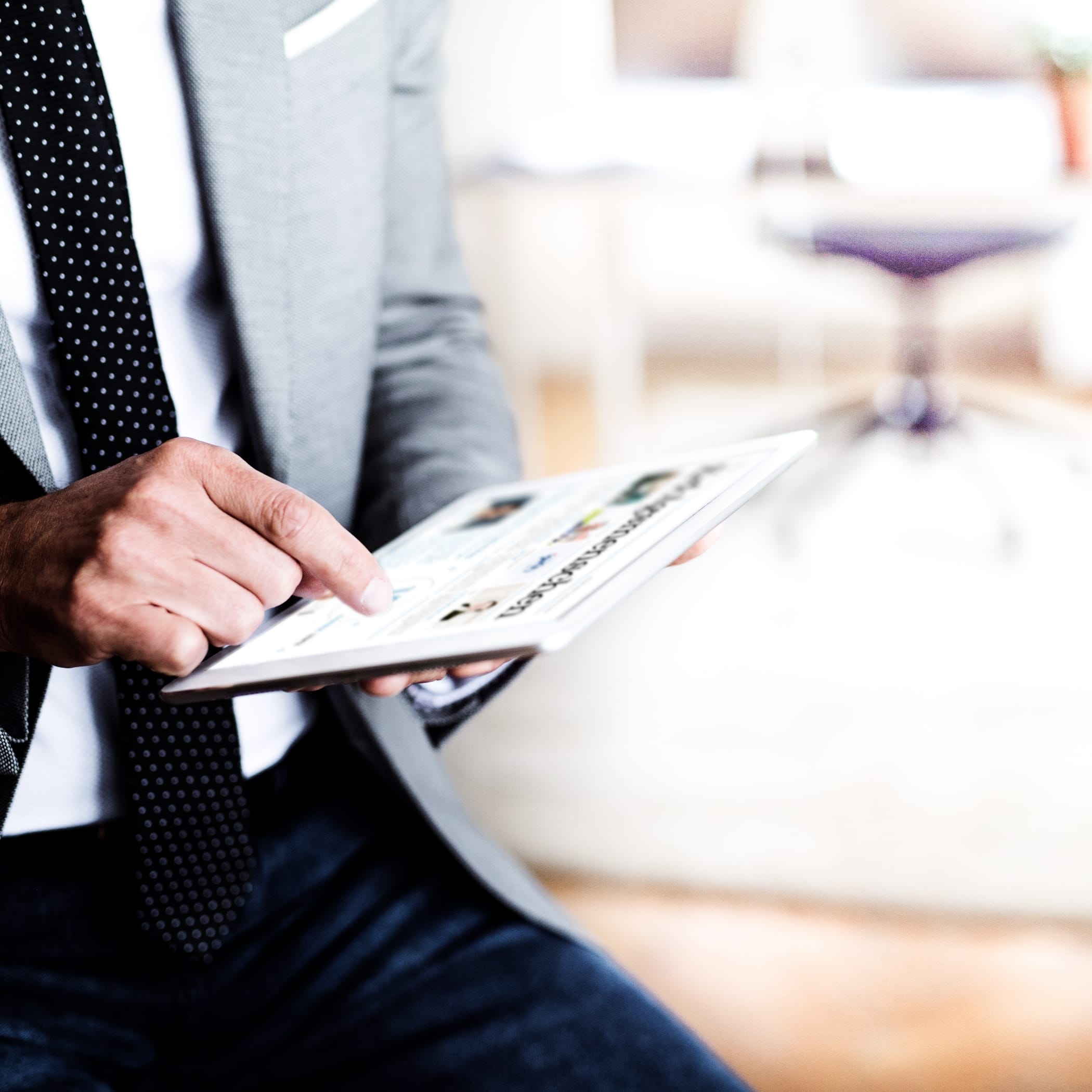 hochzwei_hwbmagazin_teaser_02.jpg Ein Mann im Anzug tippt auf einem Ipad