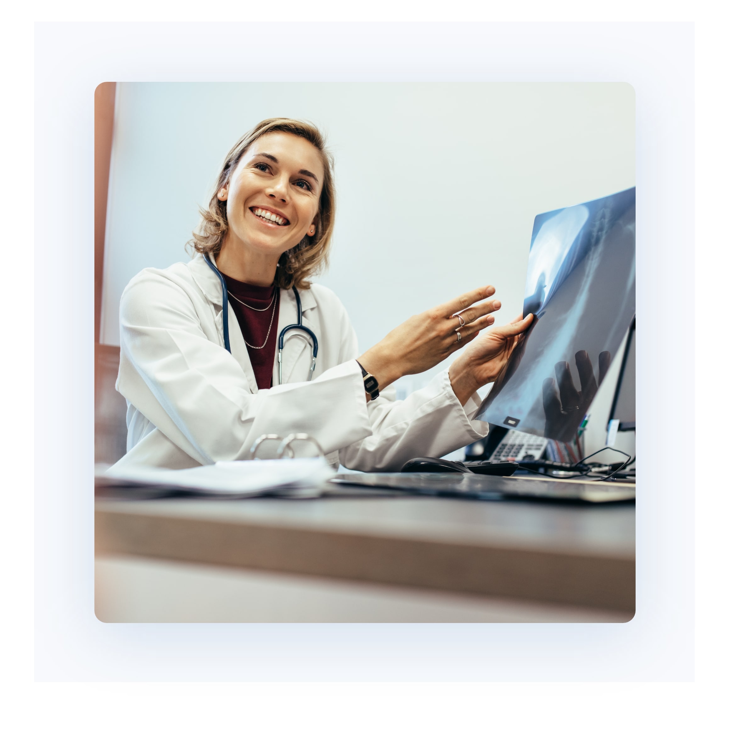 hochzwei_imla_teaser_06.jpg Eine Ärztin zeigt ihrem Patienten lächelnd ein Röntgenbild