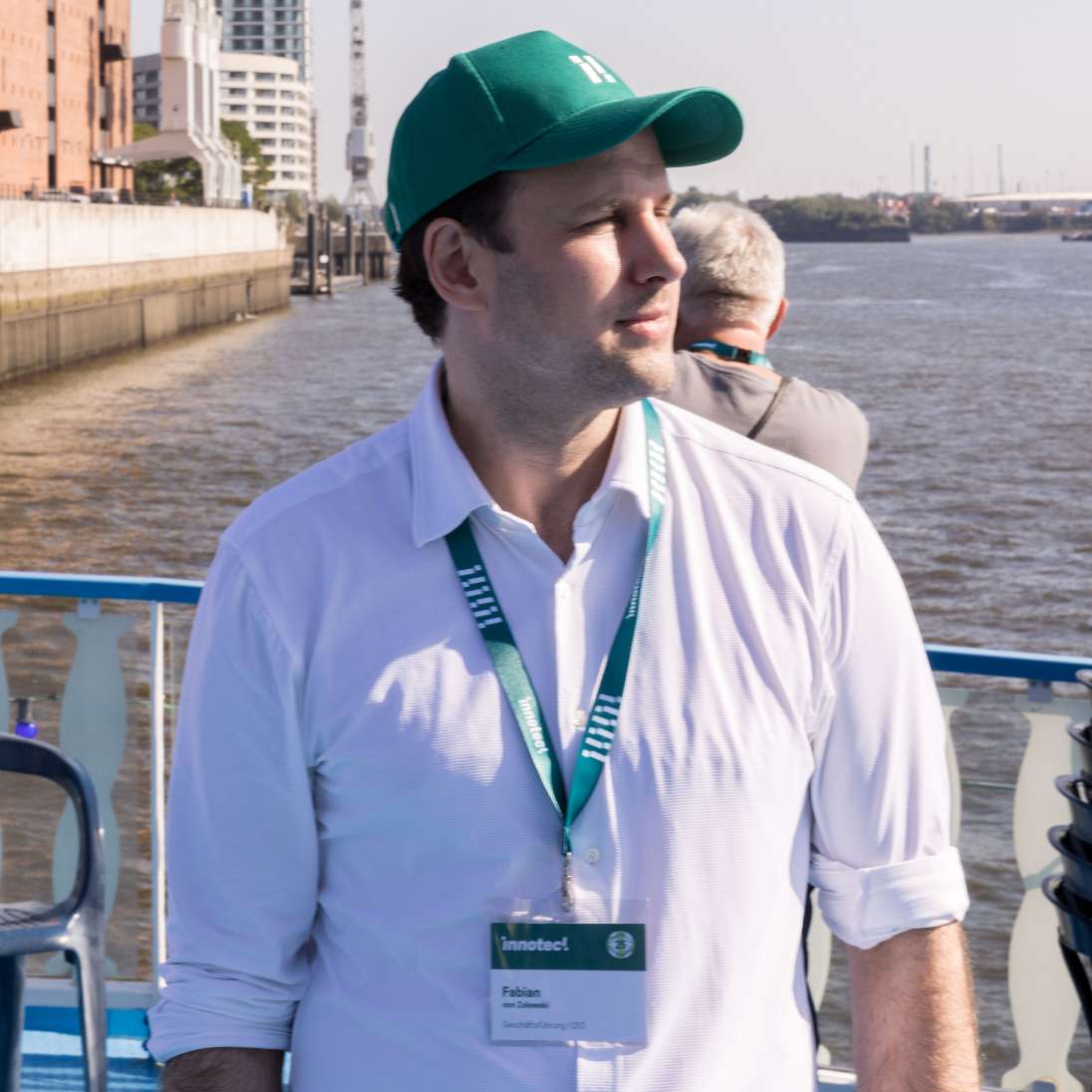 h2_innotec_teaser_16.jpg ein Mann mit innotec Schirmmütze und innotec Umhängeschild