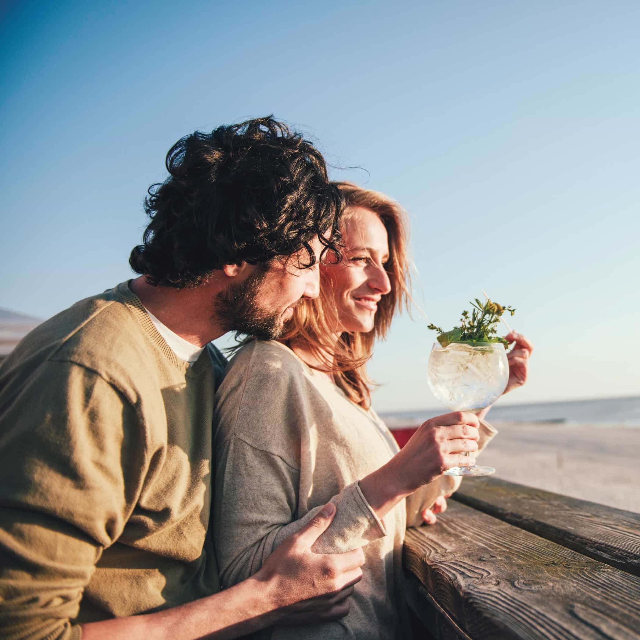 hochzwei_tsw_teaser_06.jpg Ein Pärchen steht am Strand und trinken einen Drink