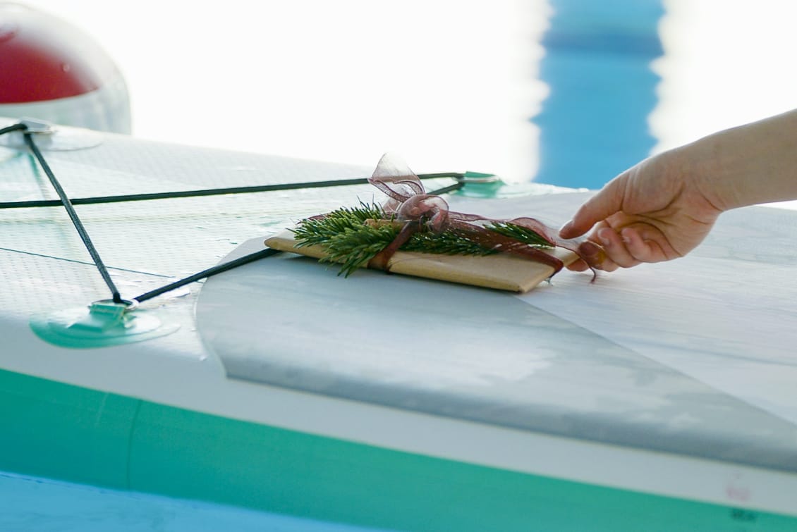 Eine Person legt ein Geschenk auf ein Surfbrett