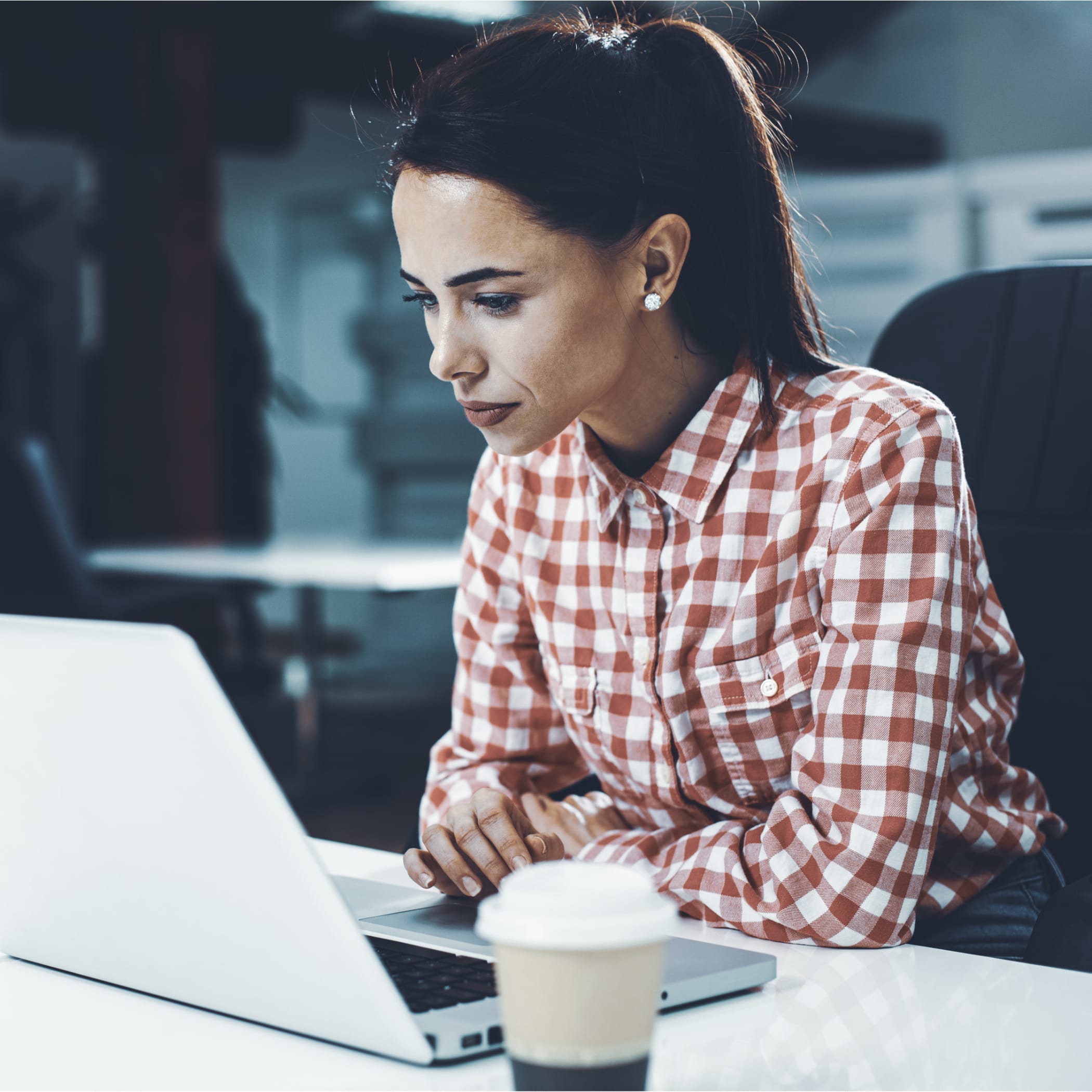 hochzwei_knpushbox_teaser_09.jpg Eine Frau im Karohemd arbeitet an ihrem Laptop