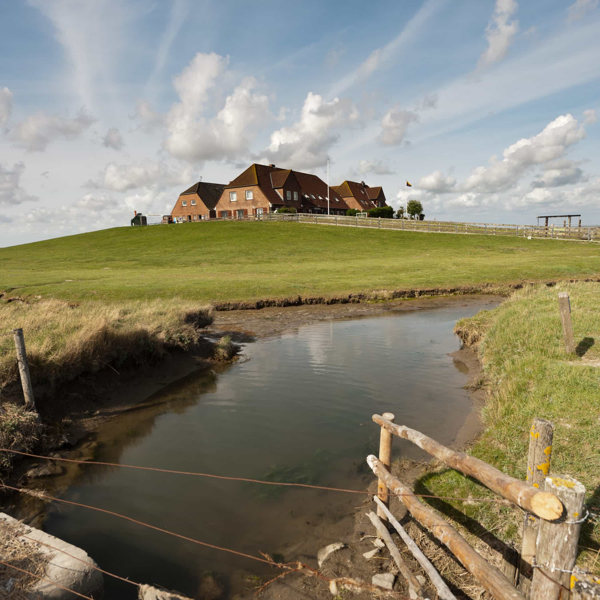 hochzwei_kiru_teaser_06.jpg Blick auf ein großes Haus am Deich