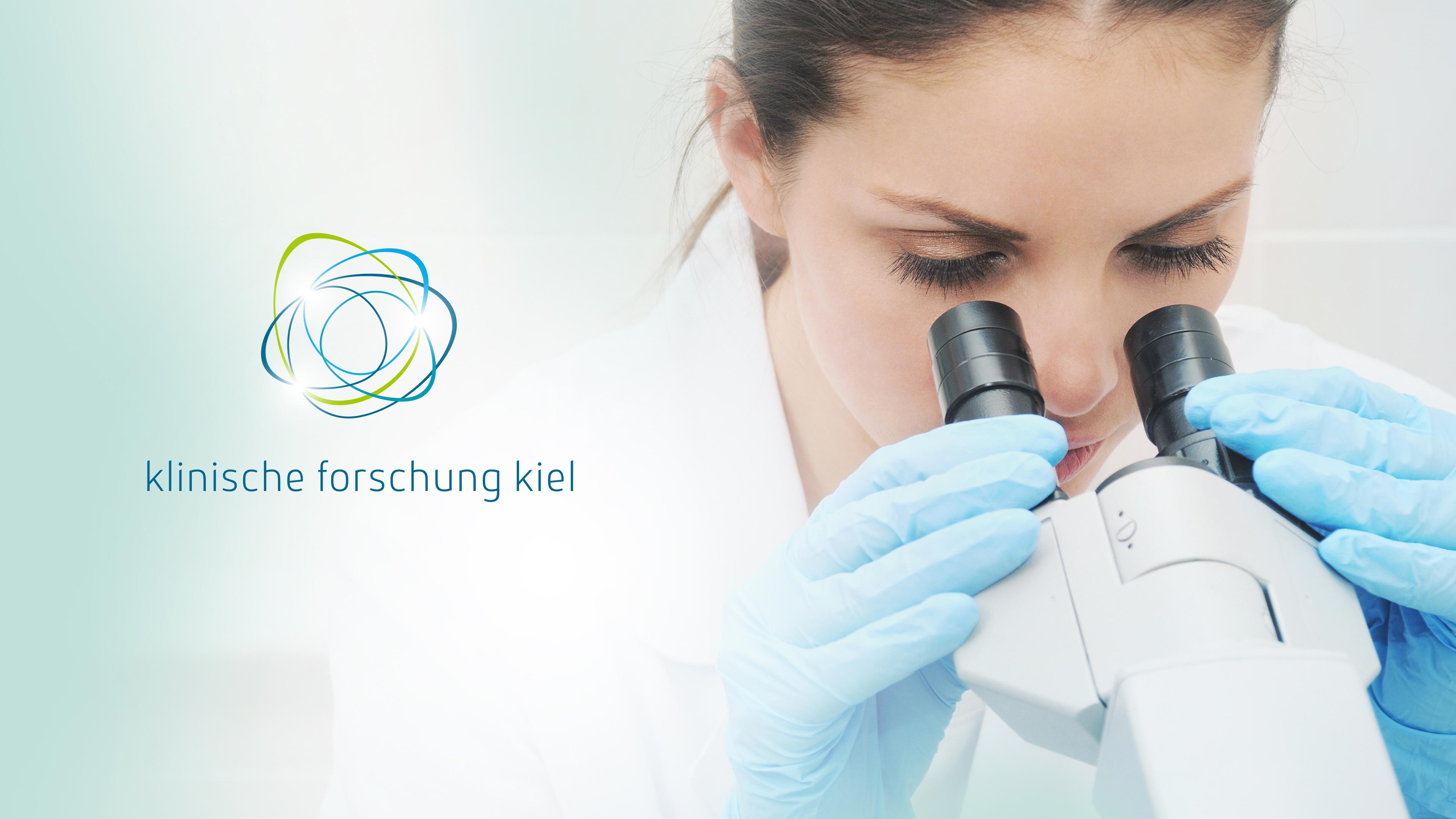 Eine brünette Frau guckt durch ein Mikroskop