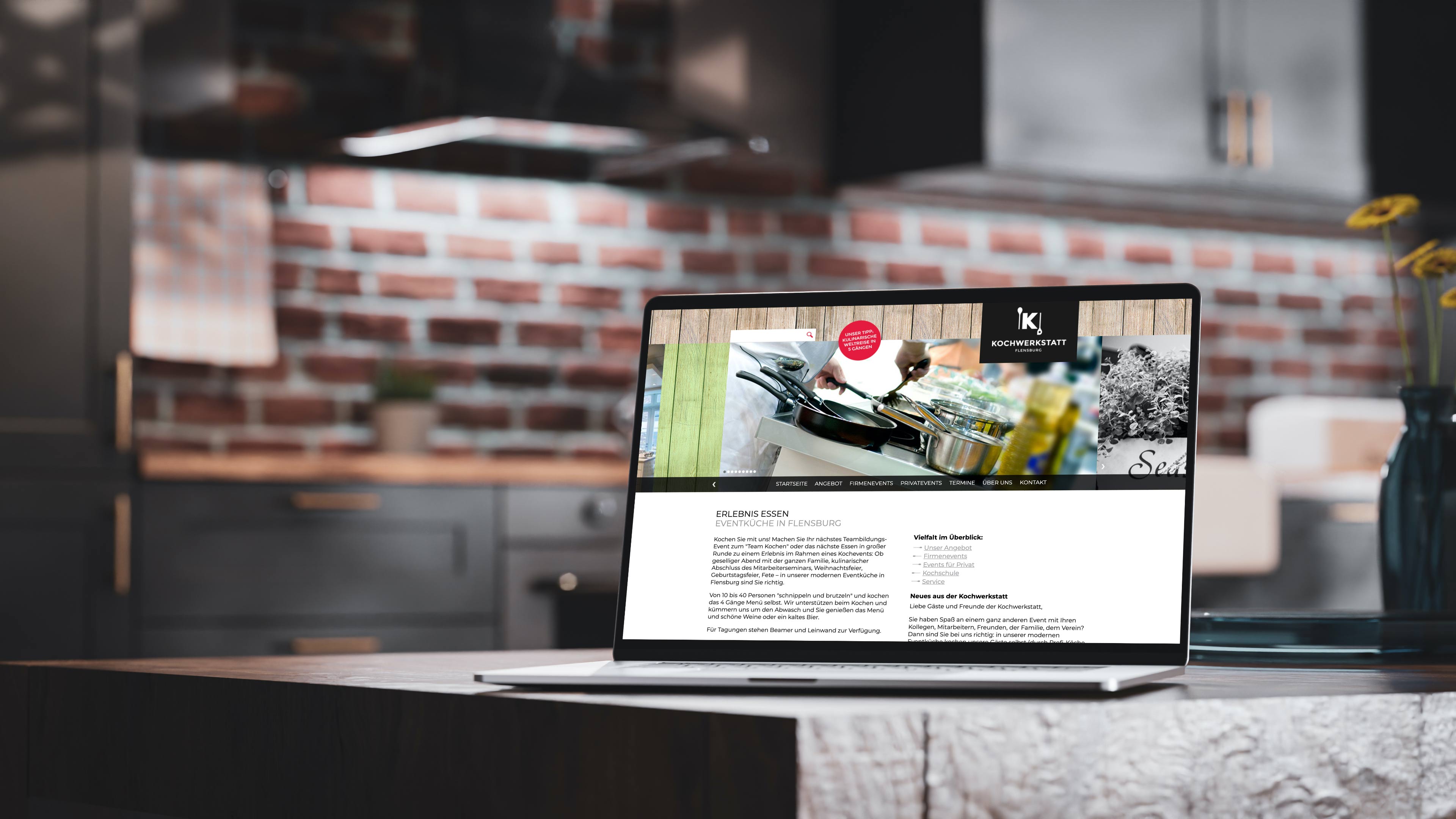 Laptop steht auf einer Küchenfläche einer modernen Küche