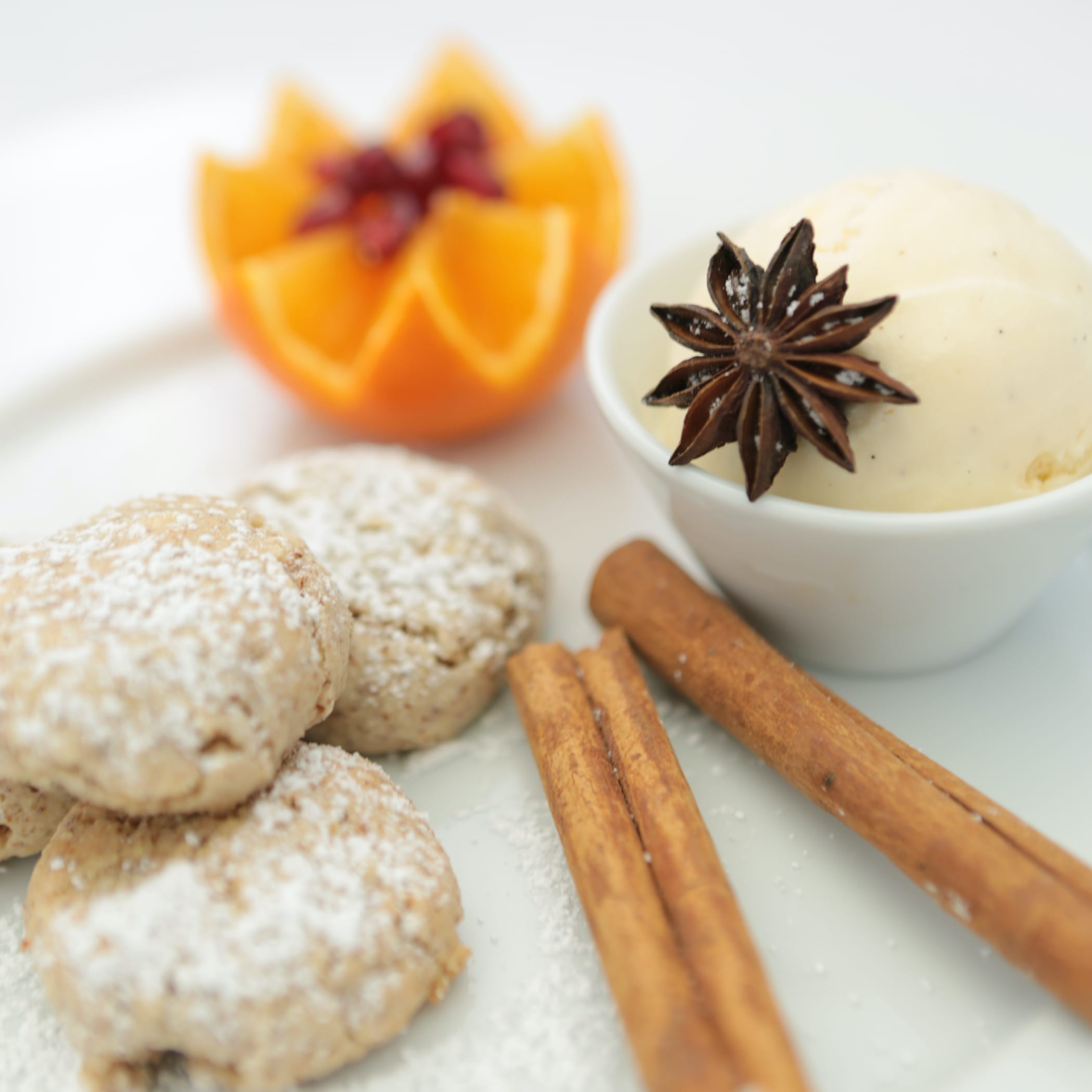 hochzwei_kowe_teaser_07.jpg Drei Kekse liegen neben einer Zimtstange auf einem Teller