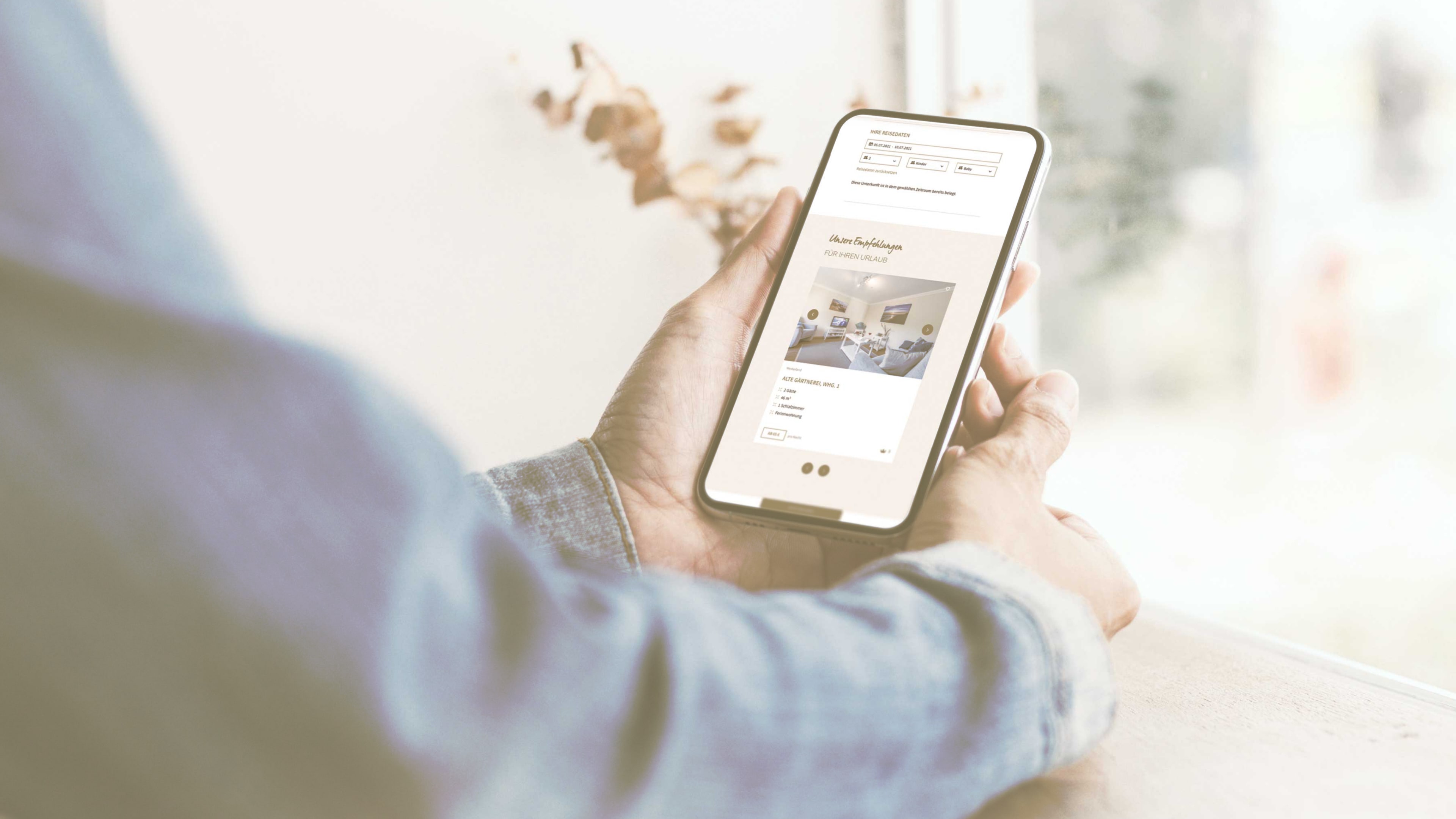 Mann surft mit seinem Handy auf der Koenig Sylt Homepage