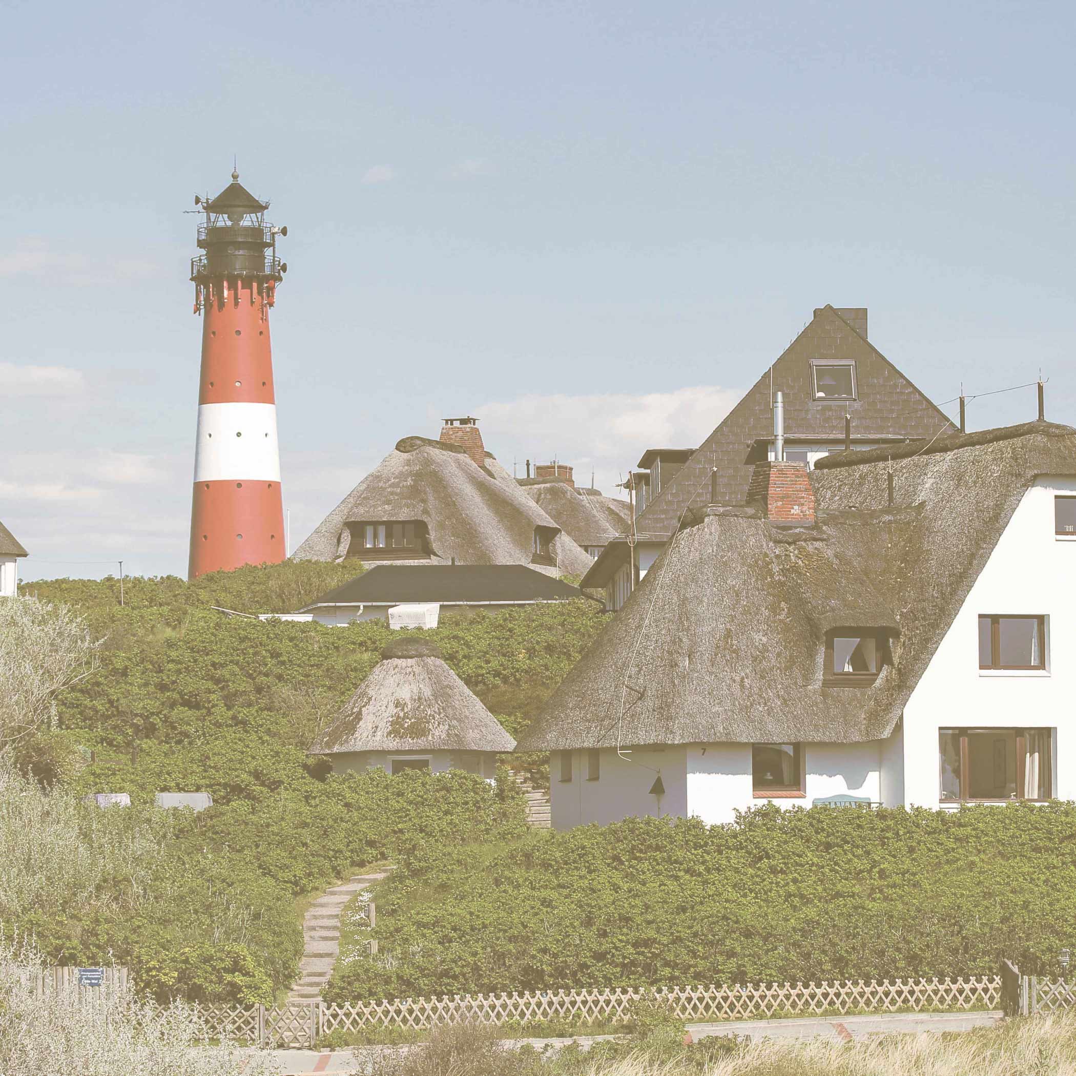 hochzwei_koens_teaser_02.jpg Blick auf eine Sylter Wohnsiedlung mit weißen Häusern