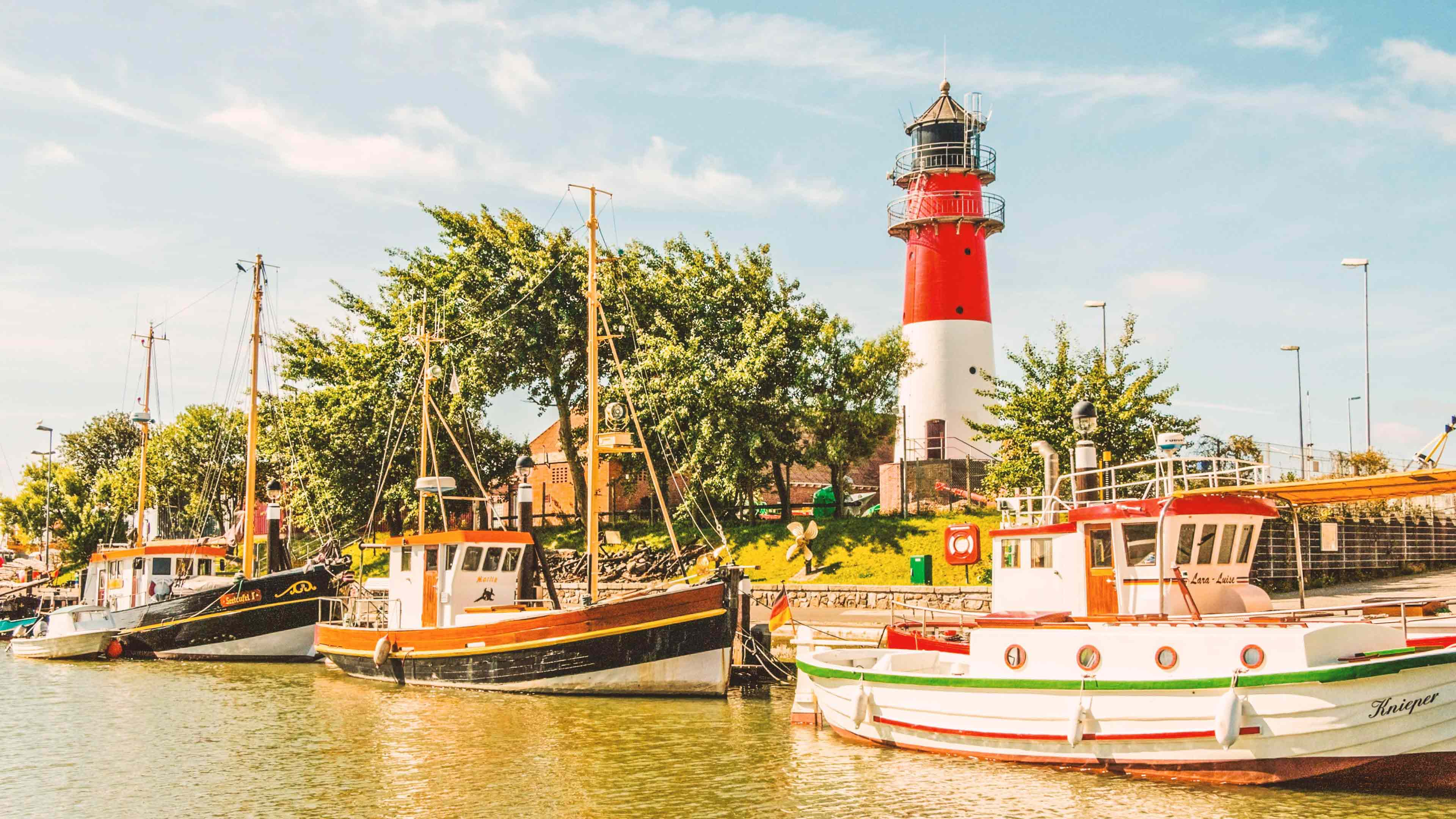 Drei Kutter liegen an einem Hafen an