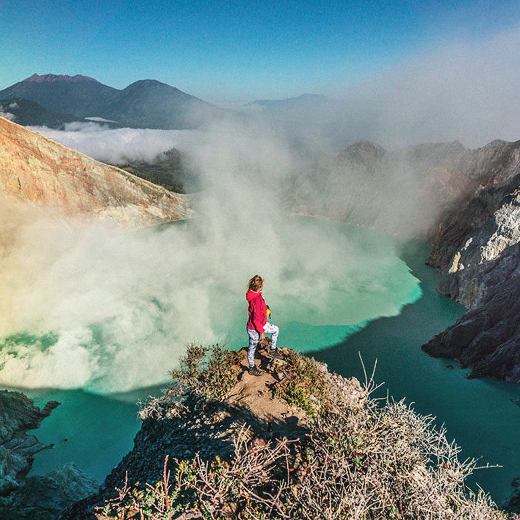 hochzwei_reisereporter_teaser_06.jpg Frau in roter Jacke steht auf einem Berg über einem See