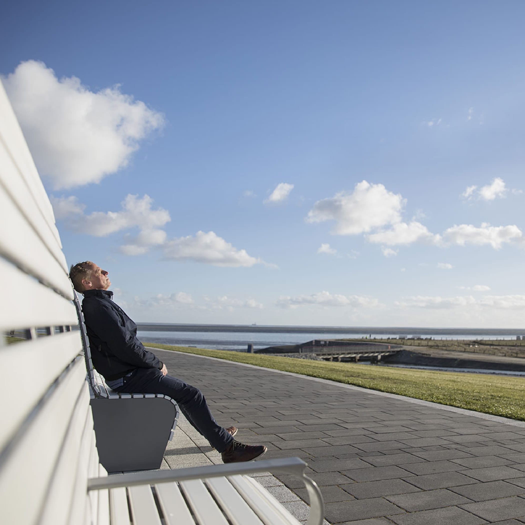 hochzwei_jess_teaser_05.jpg Ein Mann sitzt auf einer Bank und genießt die Sonne