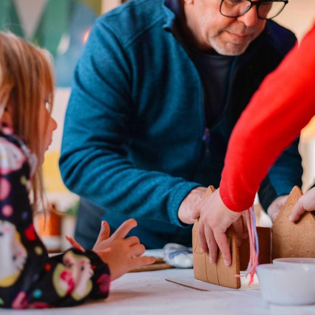 Eine Familie, die ein Spiel am Tisch spielt.