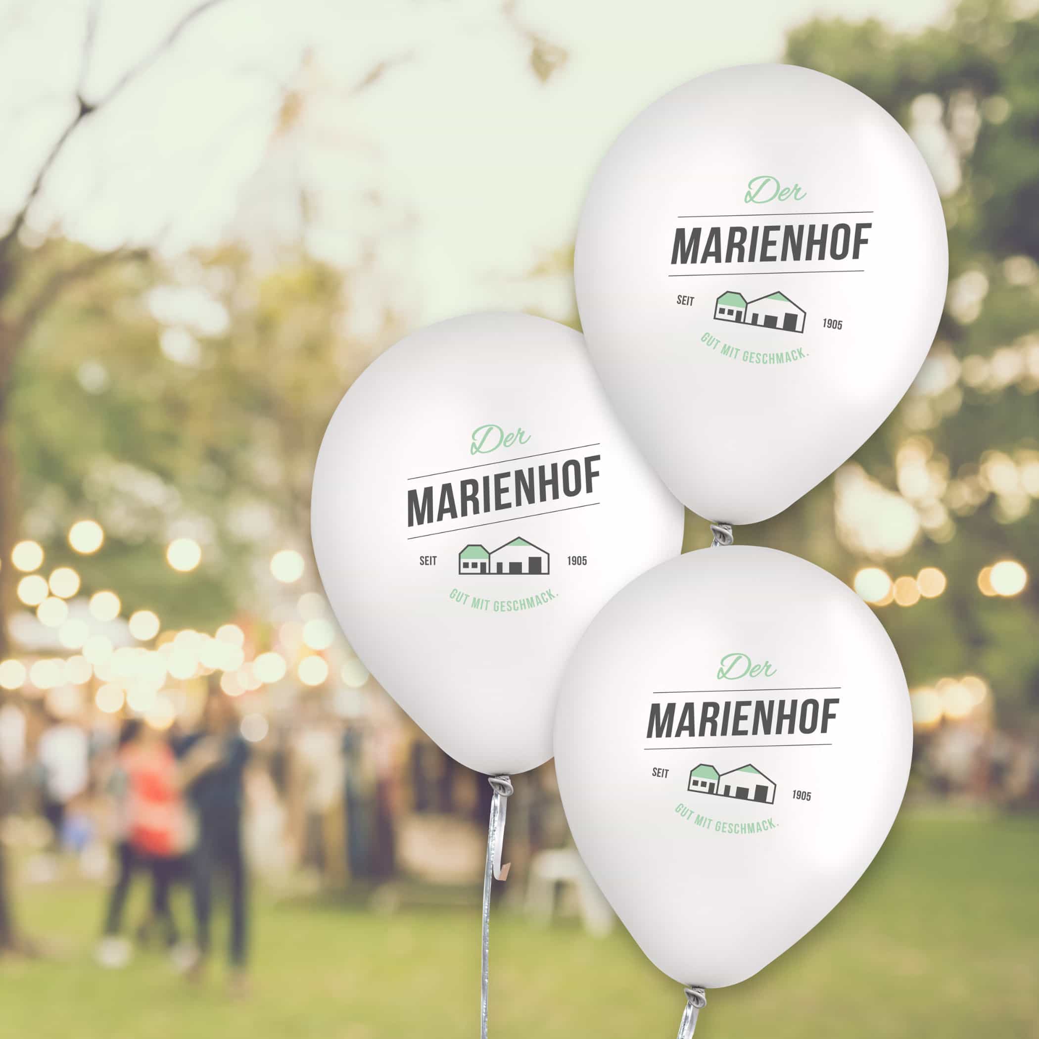 hochzwei_marienhof_teaser_07.jpg Drei weiße Ballons mit einem Aufdruck vom Logo des Marienhofes