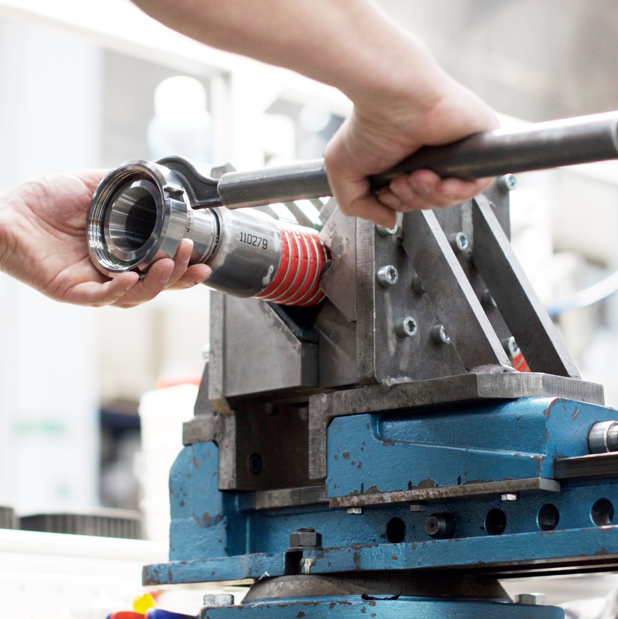 hochzwei_markert_teaser_04.jpg Zwei Hände arbeiten an einer Industriemaschine