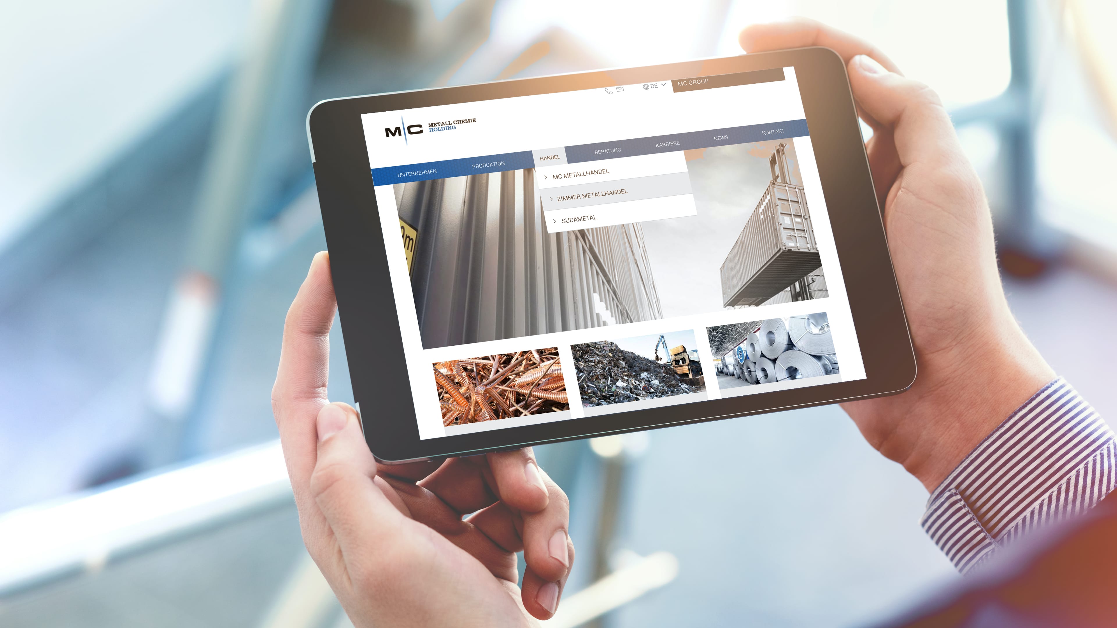 hochzwei_meche_slider_03.jpg Ein Mann trägt ein kleines Ipad in den Händen