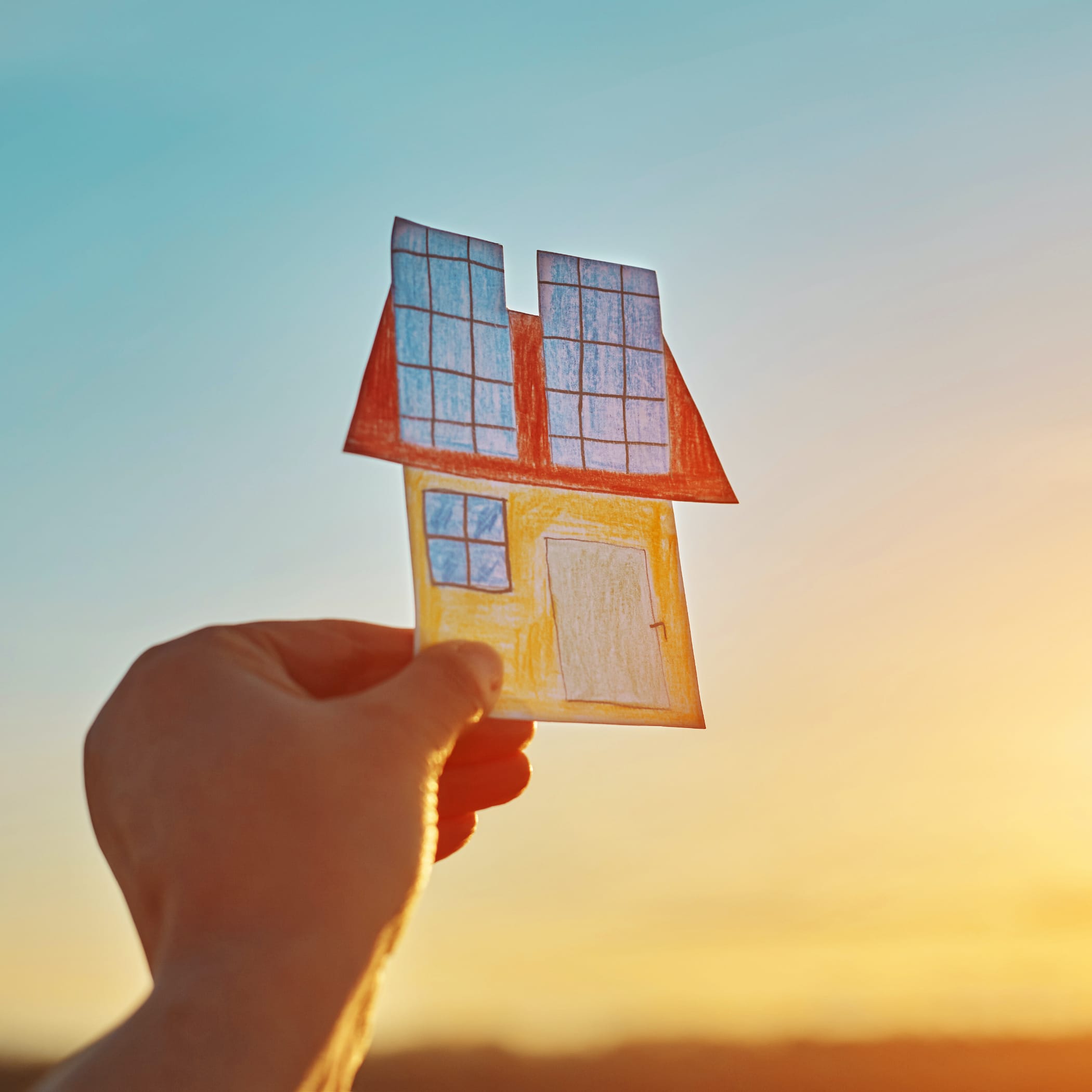 hochzwei_mini_teaser_01.jpg Hand hält ein gebasteltes Haus in die Luft