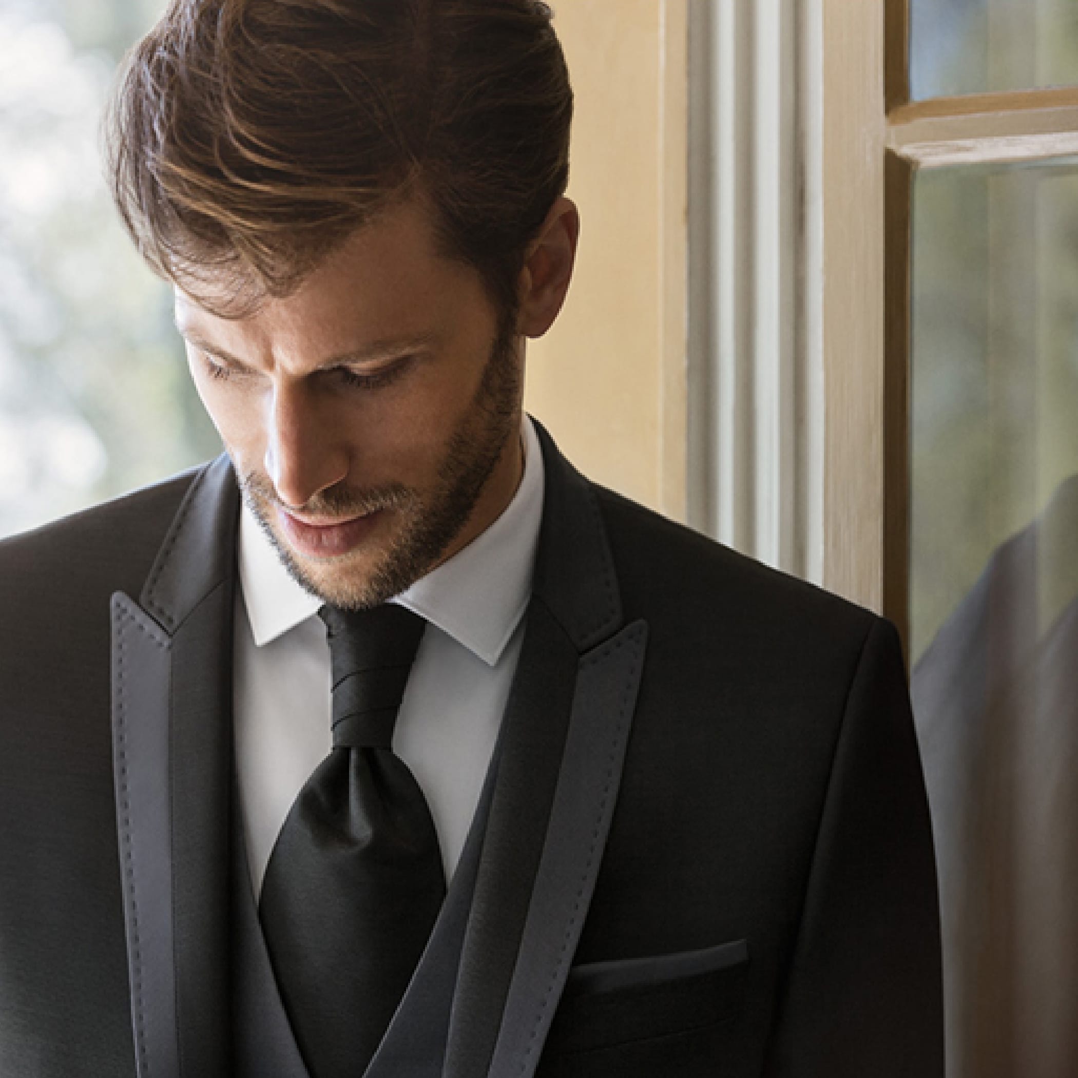 hochzwei_mmh_teaser_01.jpg Nahaufnahme eines brünetten Mannes im schwarzen Anzug