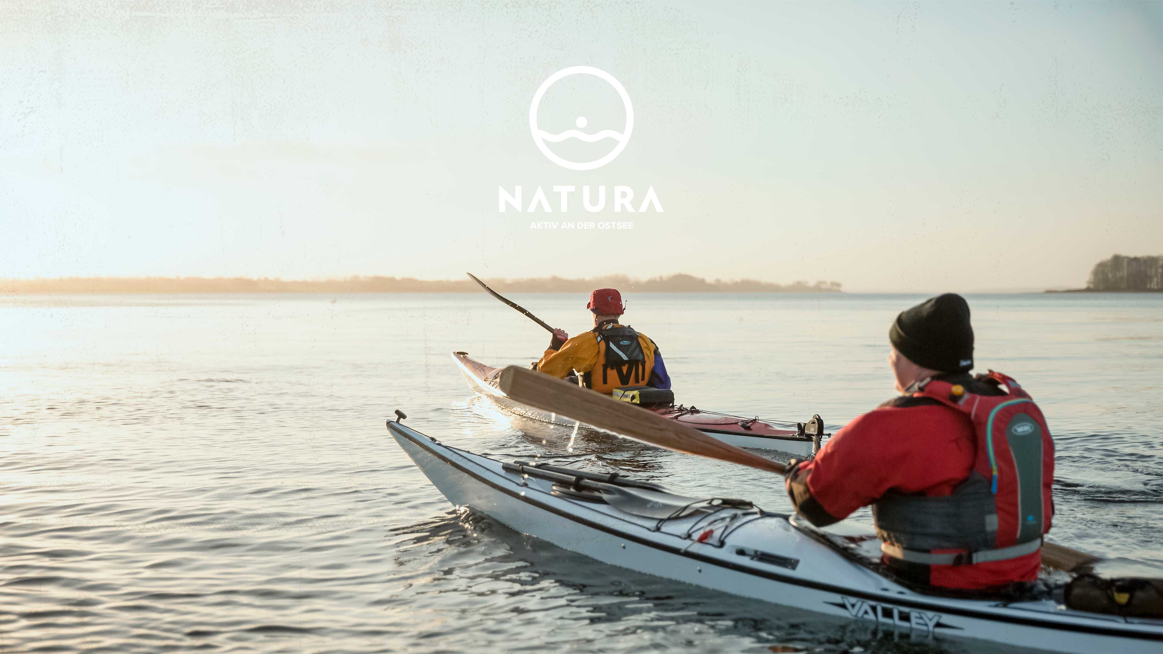 Zwei Kajakfahrer fahren in den Sonnenuntergang