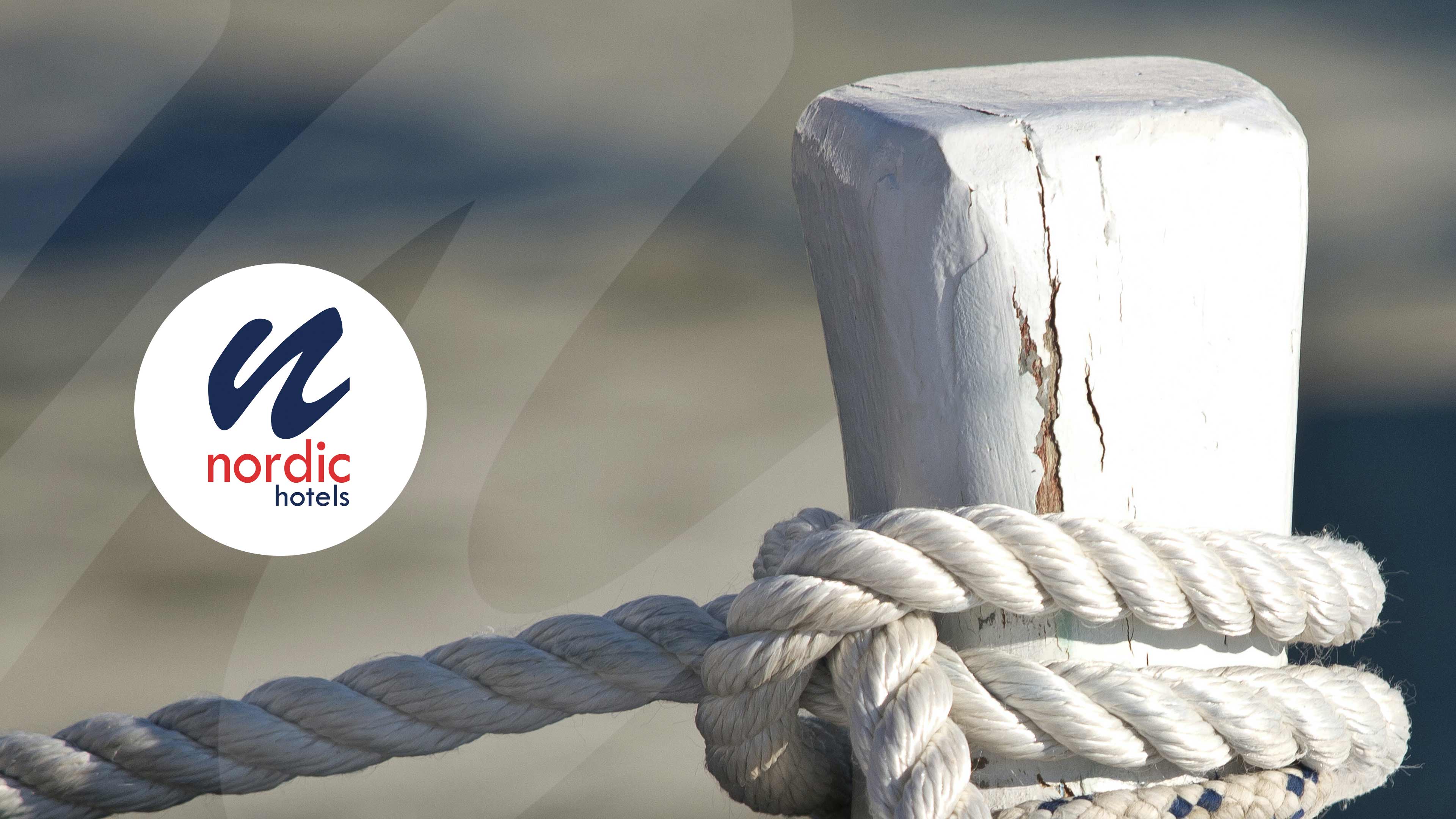 Weißer Pfosten mit Seil drumherum