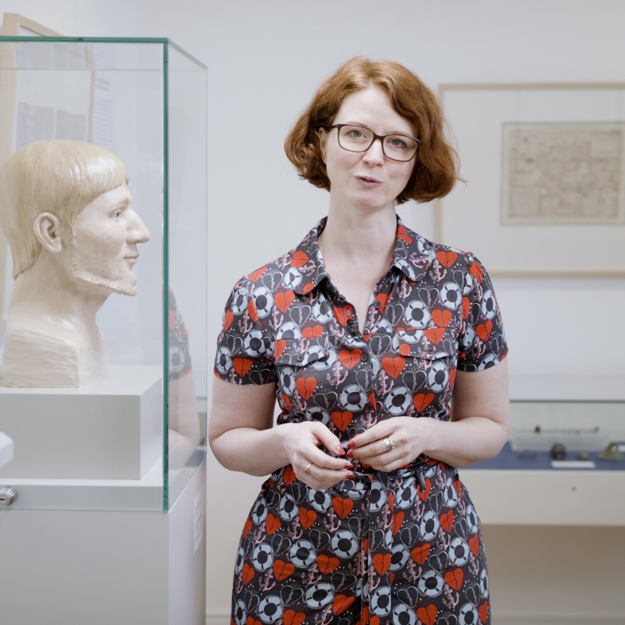 hochzwei_knsmhusum_teaser03.jpg Standbild einer rothaarigen Frau im rot schwarzen Kleid