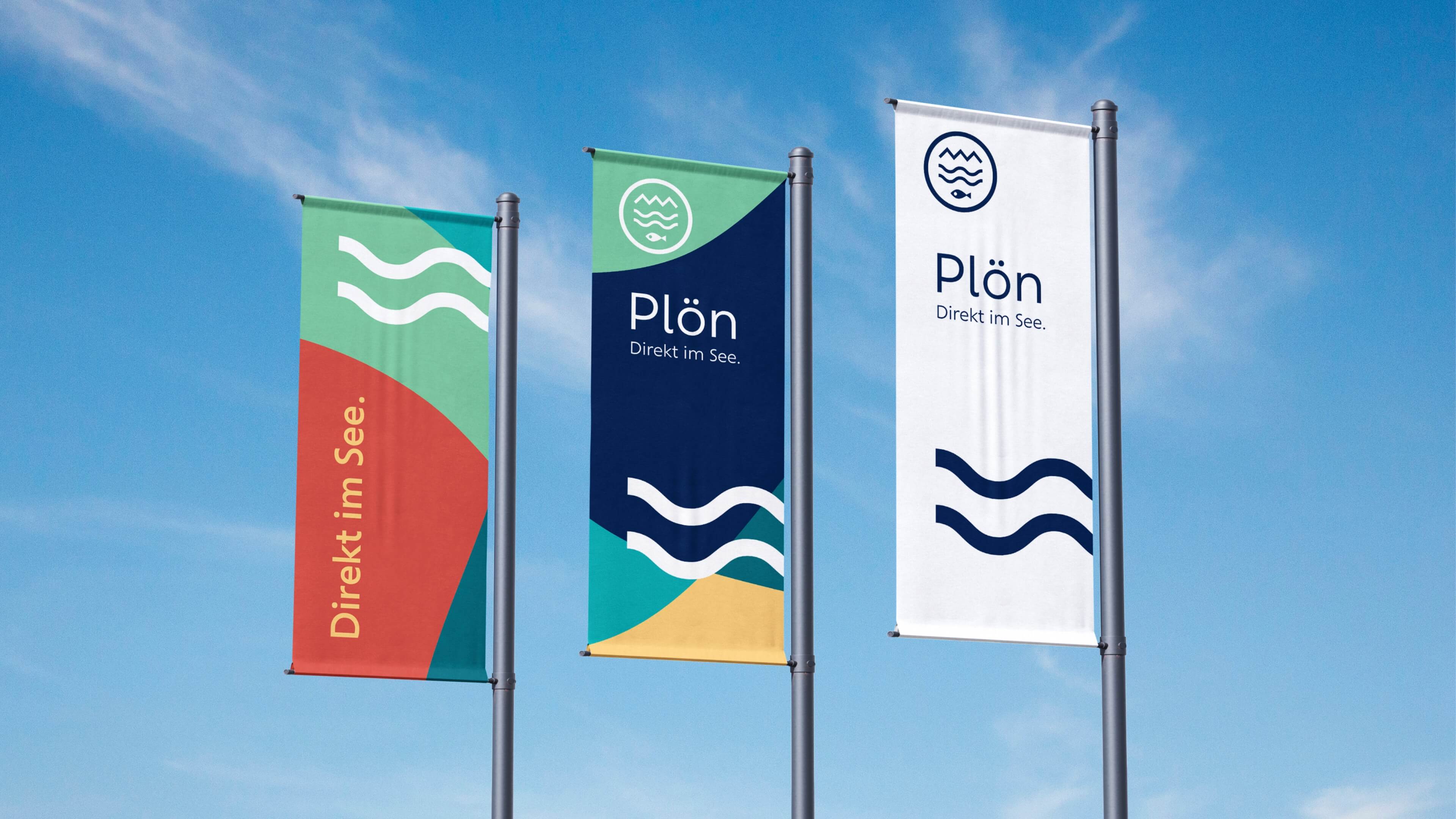 Drei Flaggen mit dem neuen Design. Sie sind modern designt mit farbigen Flächen in natürlichen Farben mit dem neuen Logo und dem Schriftzug "Plön - direkt im See."