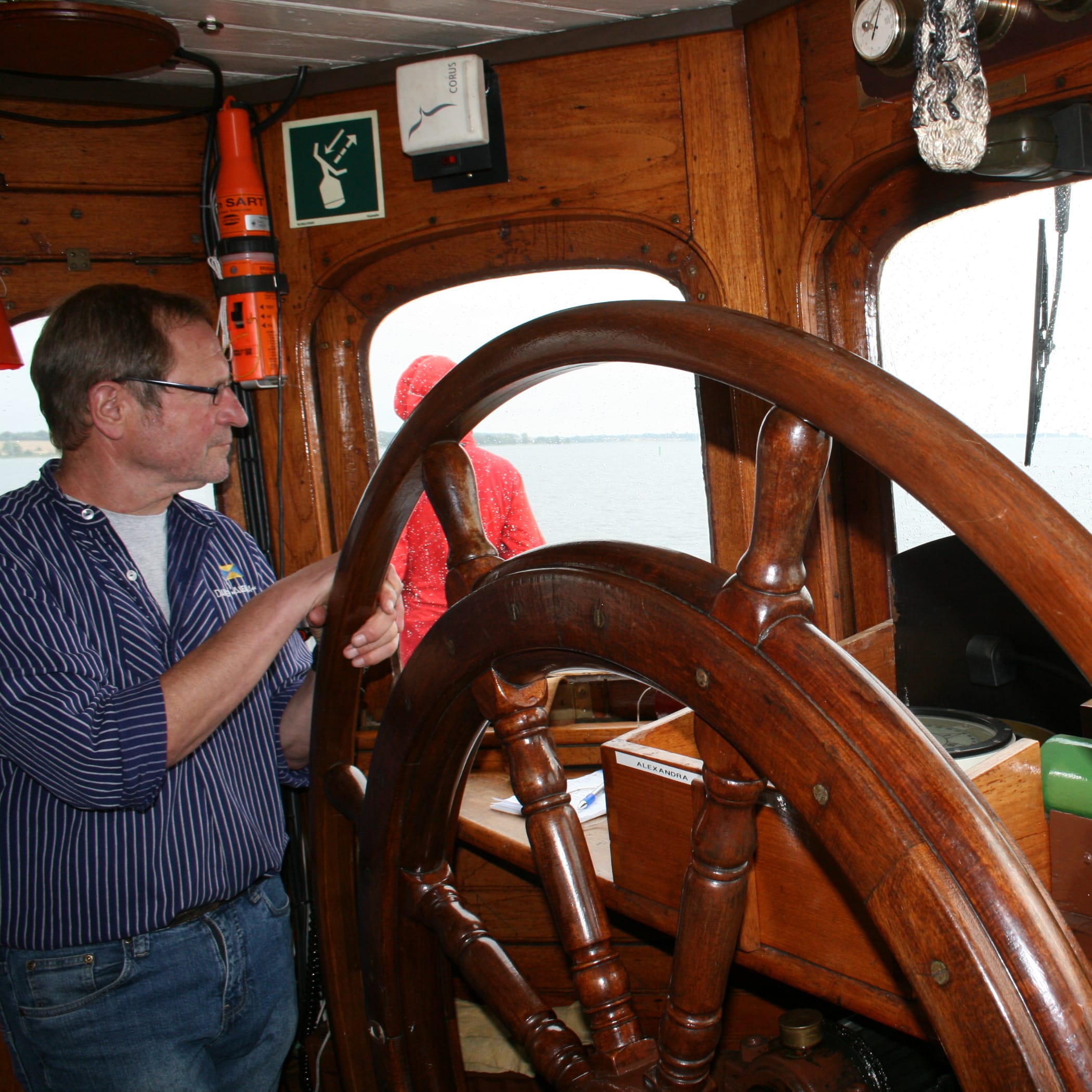 hochzwei_fvsa_teaser_08.jpg Mann steht am Ruder eines Schiffes